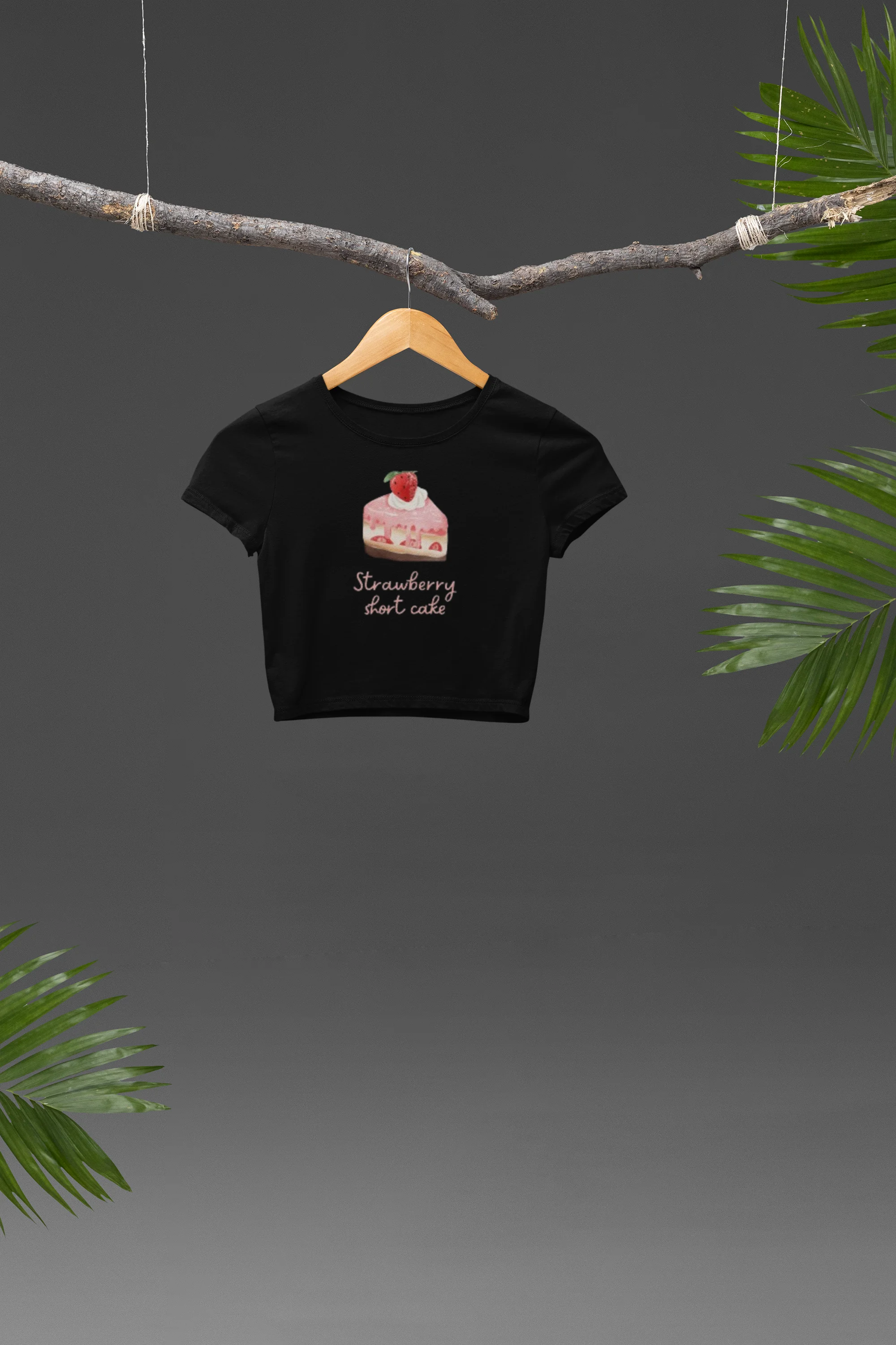 Front view of a stylish black crop top with a playful strawberry shortcake design, exuding confidence and personality.