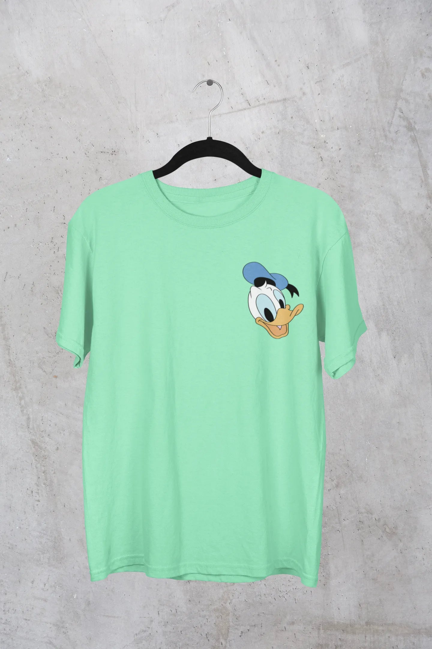 Front view of mint green oversized Disney collection t-shirt featuring a classic Donald Duck design .