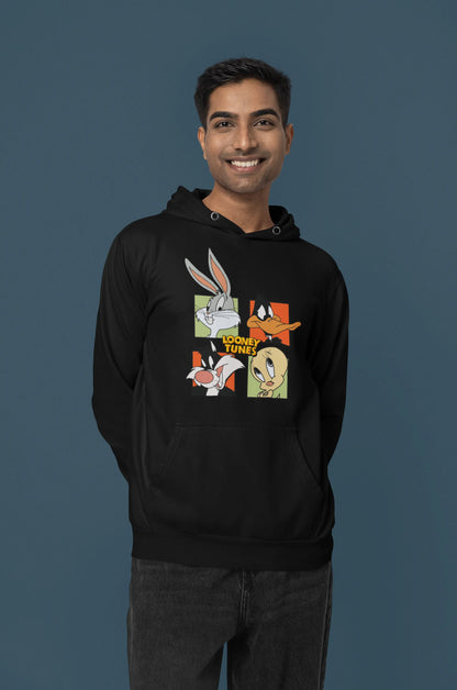 Third image of a male model wearing a black hoodie with a large Looney Tunes design. The illustration features portraits of several iconic Looney Tunes characters.