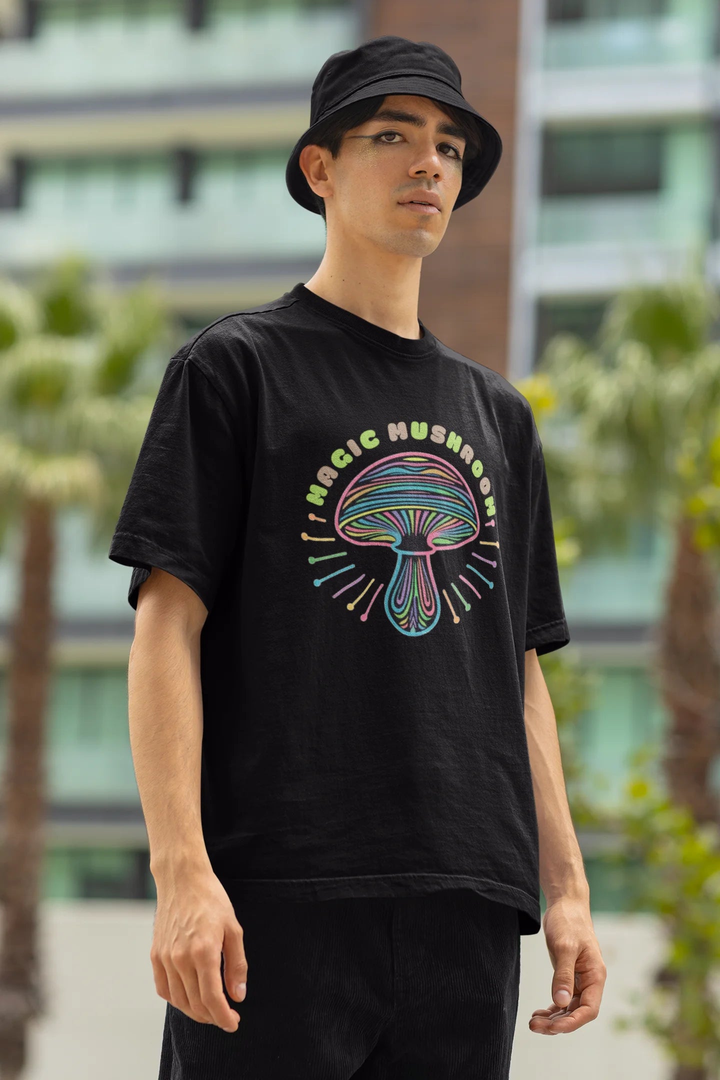 Right side view of a male model wearing a black oversized t-shirt featuring a psychedelic magic mushroom with an aura, perfect for a hippie, trance, or groovy style.