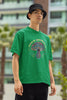 Right side view of a male model wearing a forest green oversized t-shirt featuring a psychedelic magic mushroom with an aura, perfect for a hippie, trance, or groovy style.