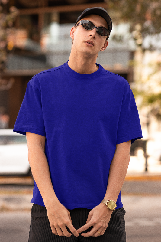 First front view of a male model wearing a royal blue oversized t-shirt featuring Crocodile, the Desiccation Master, from the One Piece anime.