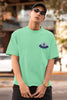 First front view of a male model wearing a mint green oversized t-shirt featuring a fun 