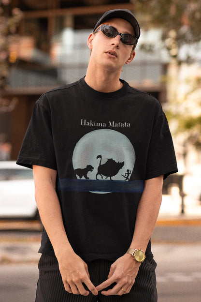 First image of male model showcasing black oversized t-shirts inspired by Hakuna Matata from Disney's Lion King, featuring Pumbaa, Simba and other iconic characters.