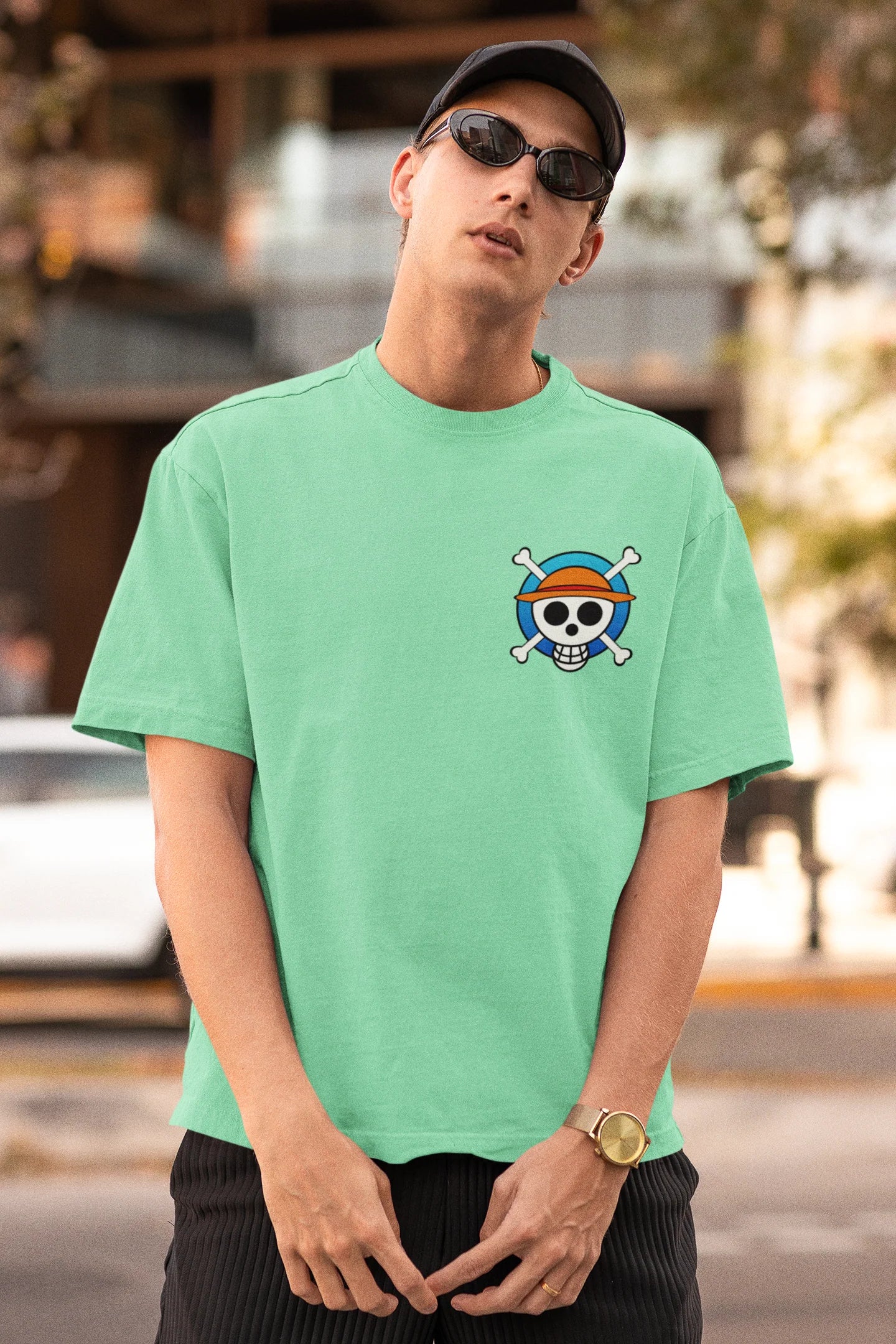 First front view of a male model wearing a mint green oversized t-shirt featuring chibi versions of the main characters from the One Piece anime.