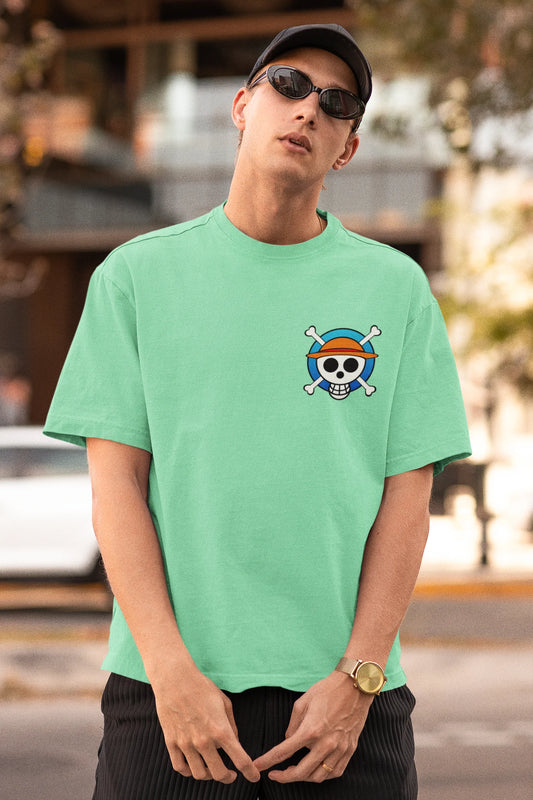 First front view of a male model wearing a mint green oversized t-shirt featuring chibi versions of the main characters from the One Piece anime.