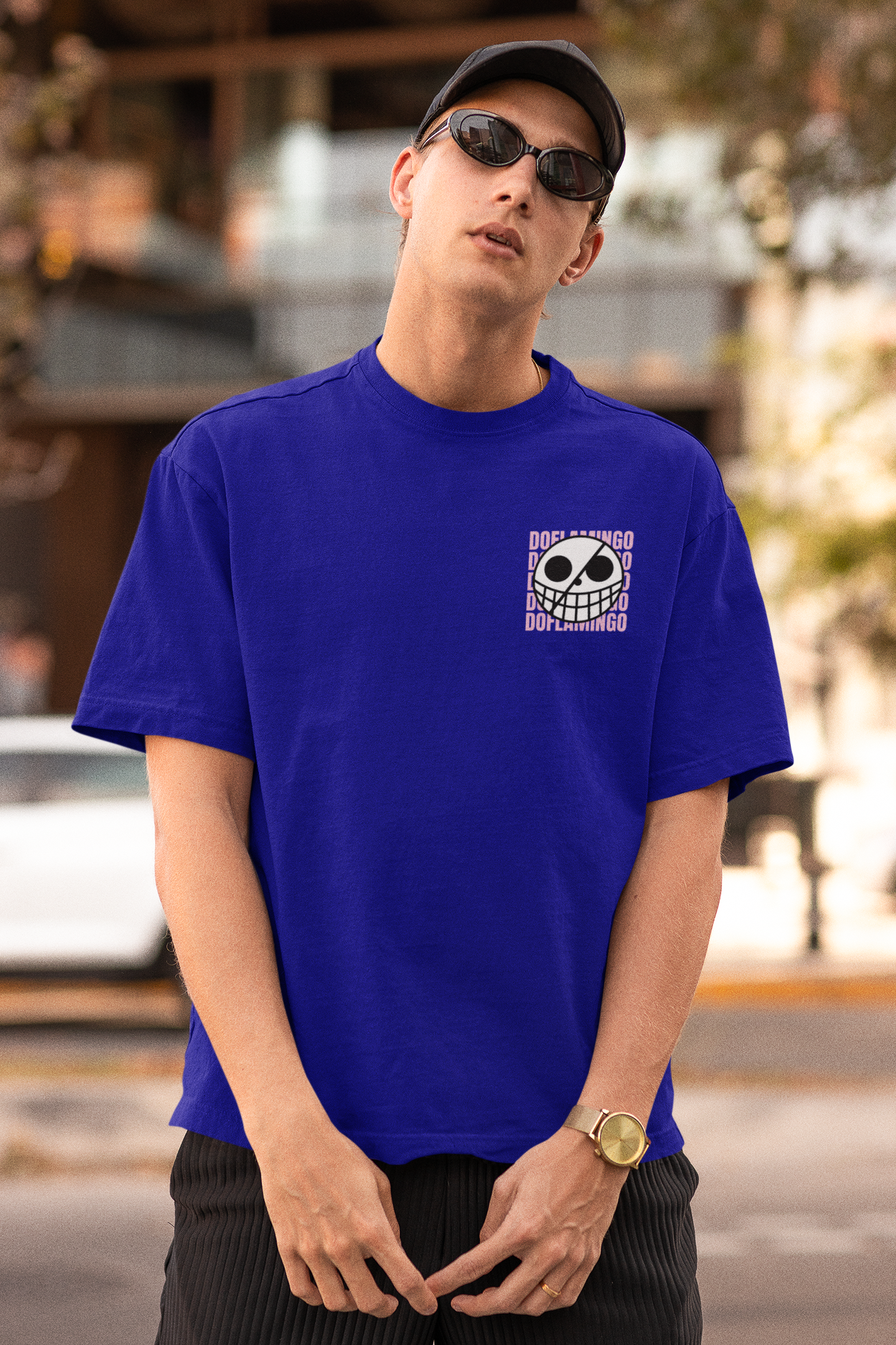 First front view of a male model wearing a royal blue oversized t-shirt featuring Donquixote Doflamingo from the One Piece anime.