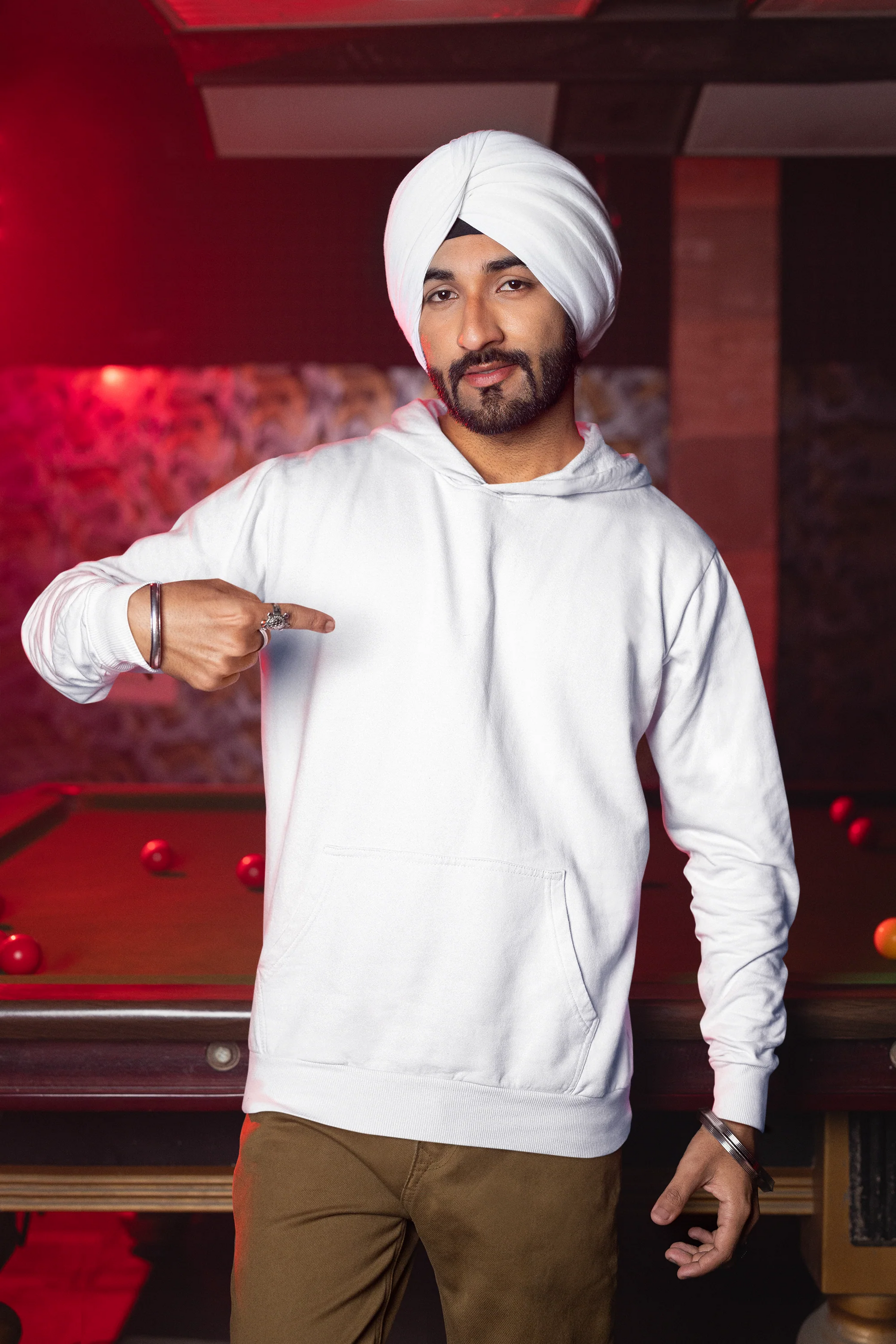 Second front view of a male model wearing a comfortable white hoodie featuring the phrase "Vibe Teri Meri" in a modern font on a portrait of Diljit Singh holding up a sunflower, perfect for expressing your unique style and feeling the rhythm.