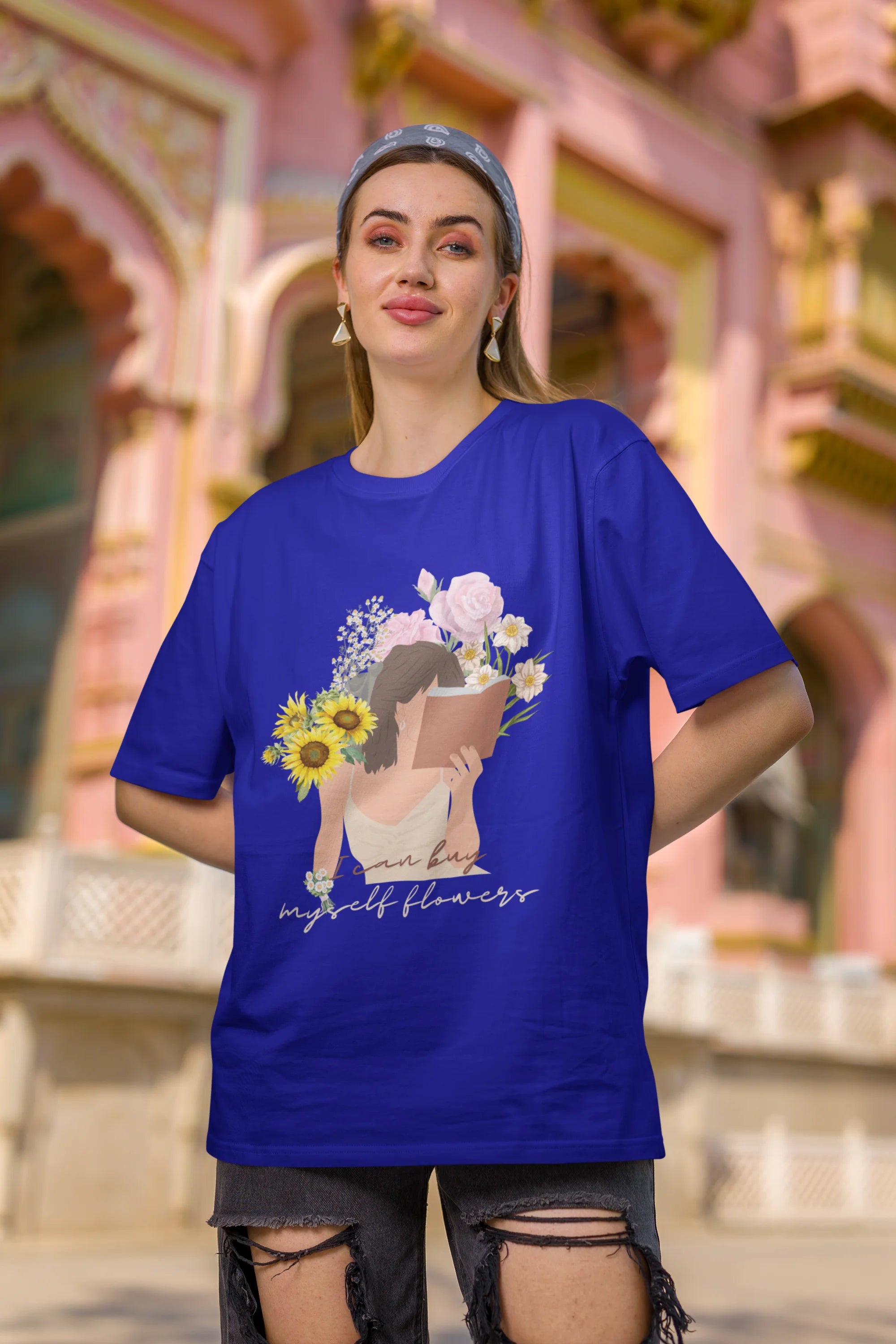 Second front view of female model wearing a royal blue oversized t-shirt with a positive message "Buy Myself Flowers" and a graphic of a smiling woman surrounded by tulips and sunflowers. Ideal for those who love inspirational clothing and floral designs.