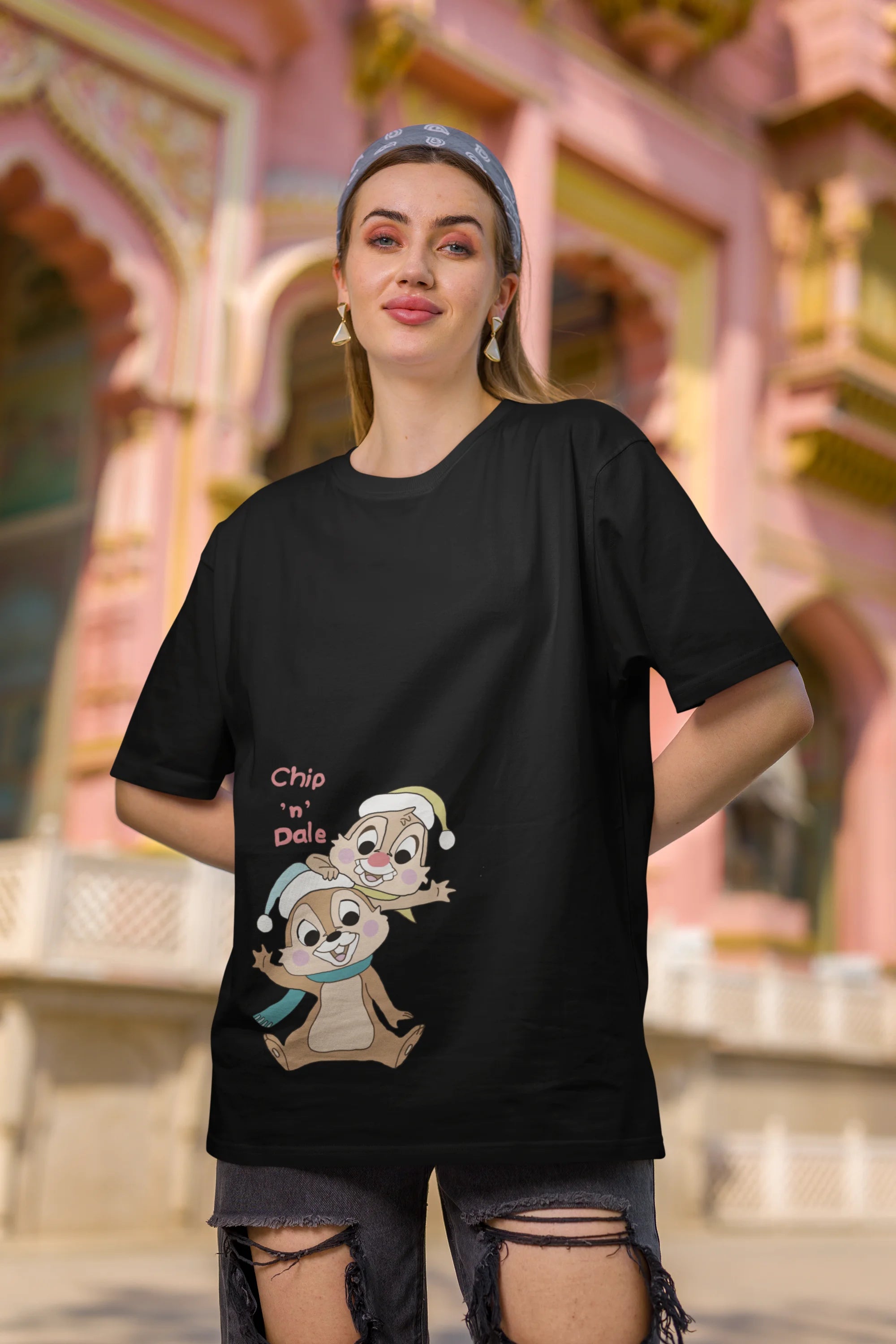 Third image of female model wearing black oversized tee with a Disney's Chip and Dale design, featuring the adorable duo in a playful scene.