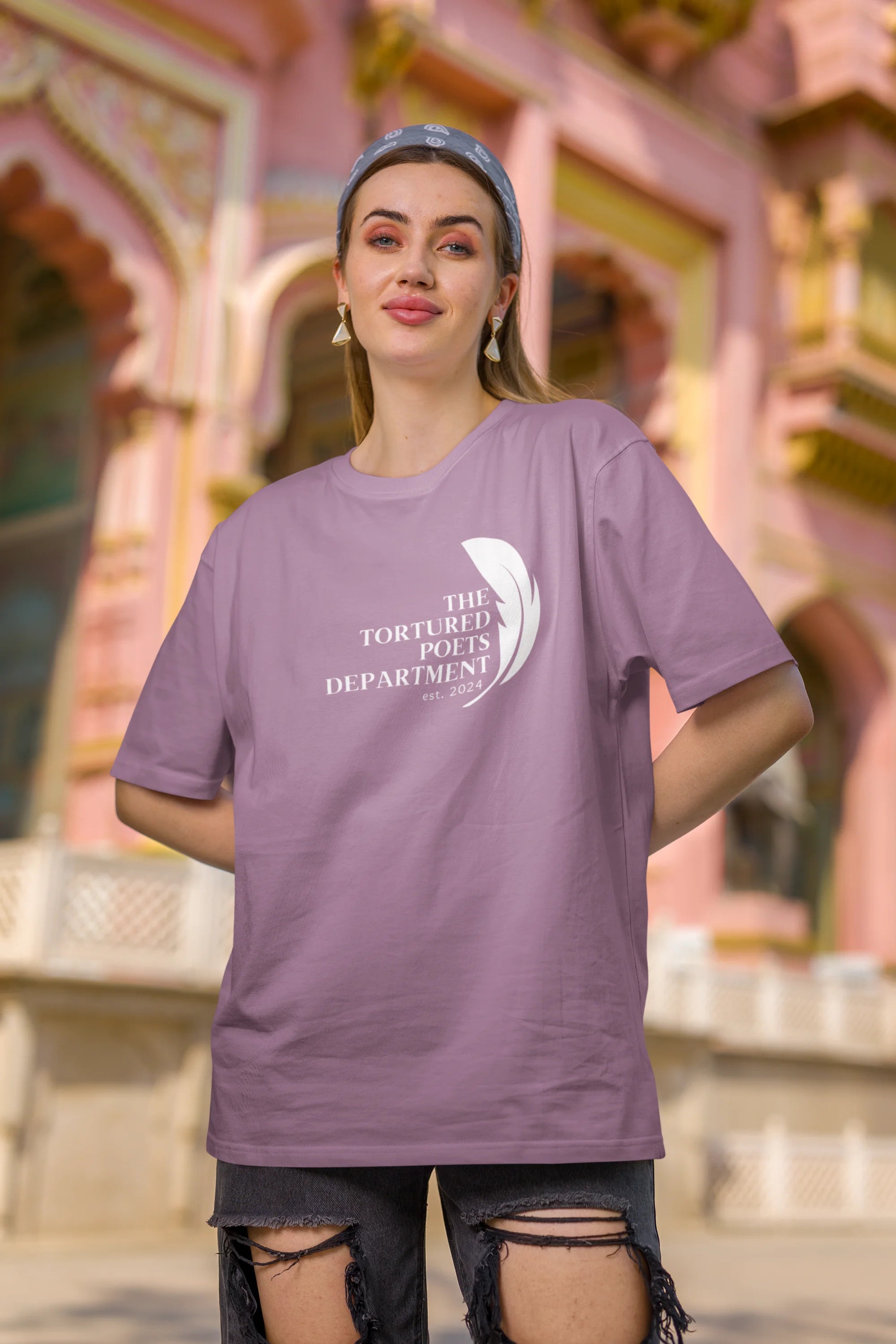 First image of woman wearing dirty purple coloured Oversized Taylor Swift T-Shirt featuring TTPD design.