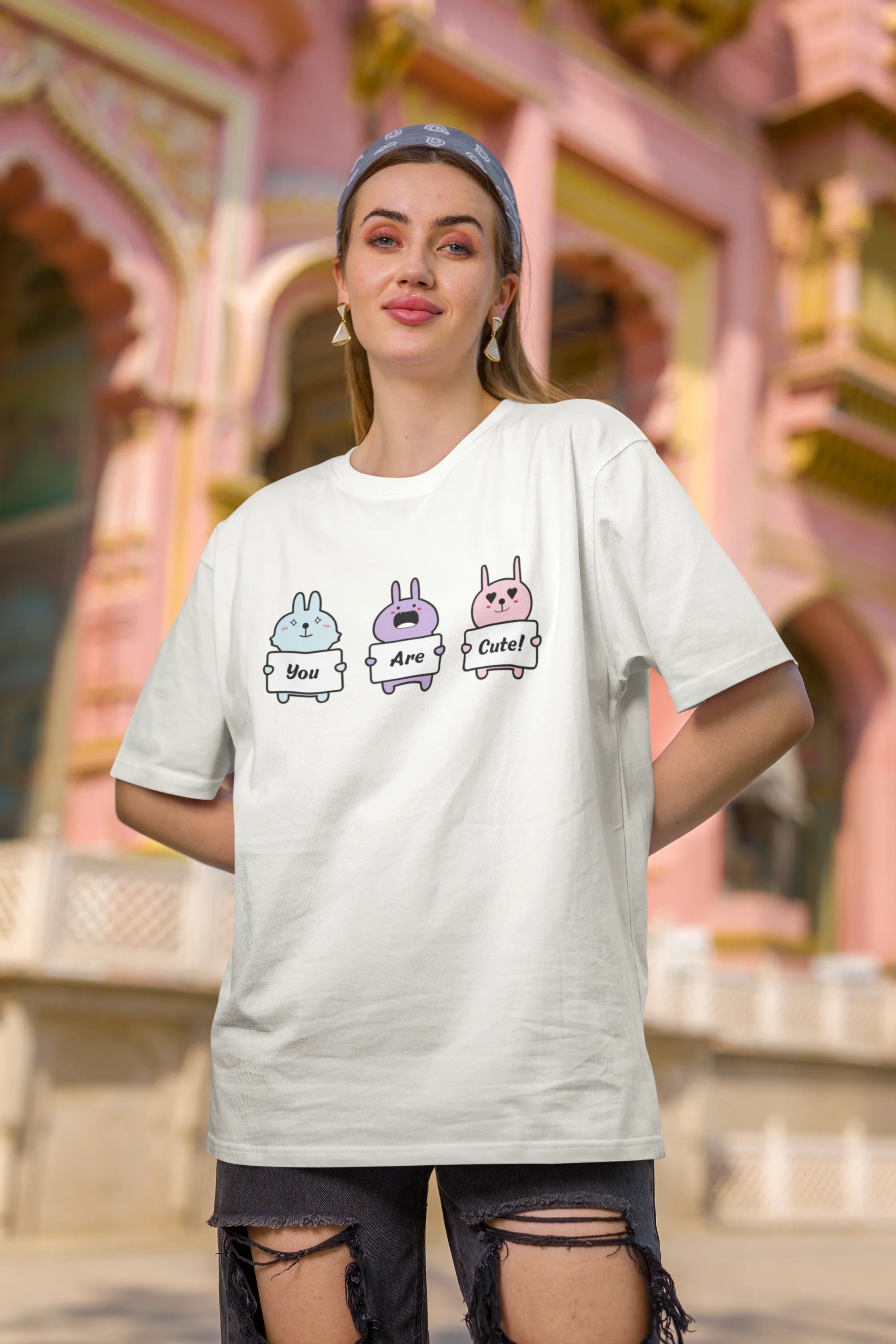 Second image of female model wearing Disney-themed off-white oversized tee with a cute cartoon design