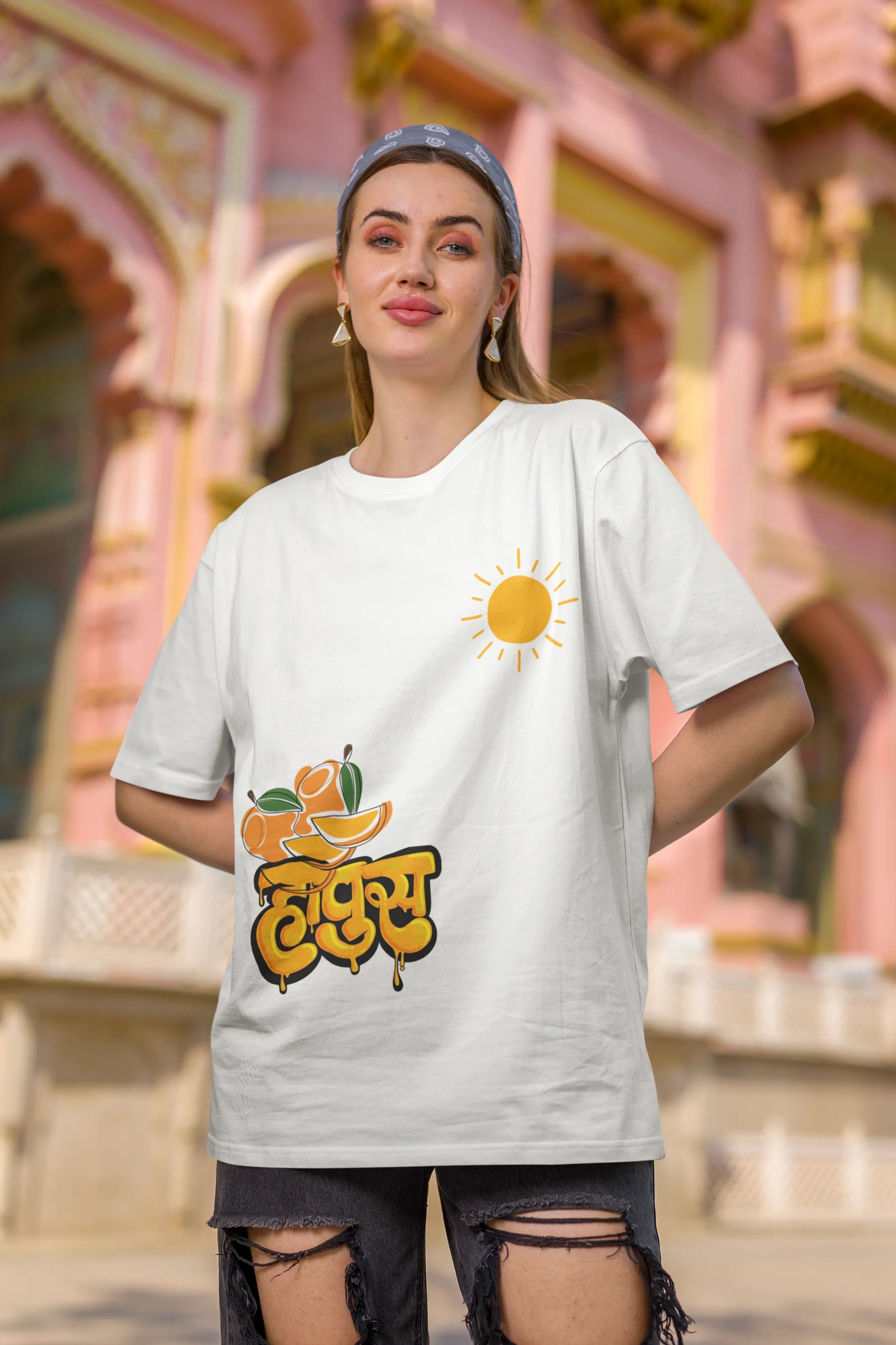 Second front view of female model wearing an off-white oversized t-shirt featuring a design inspired by the Marathi word "Hapus," meaning Alphonso mango. Ideal for fans of Marathi culture, foodies, and anyone who loves the king of fruits.