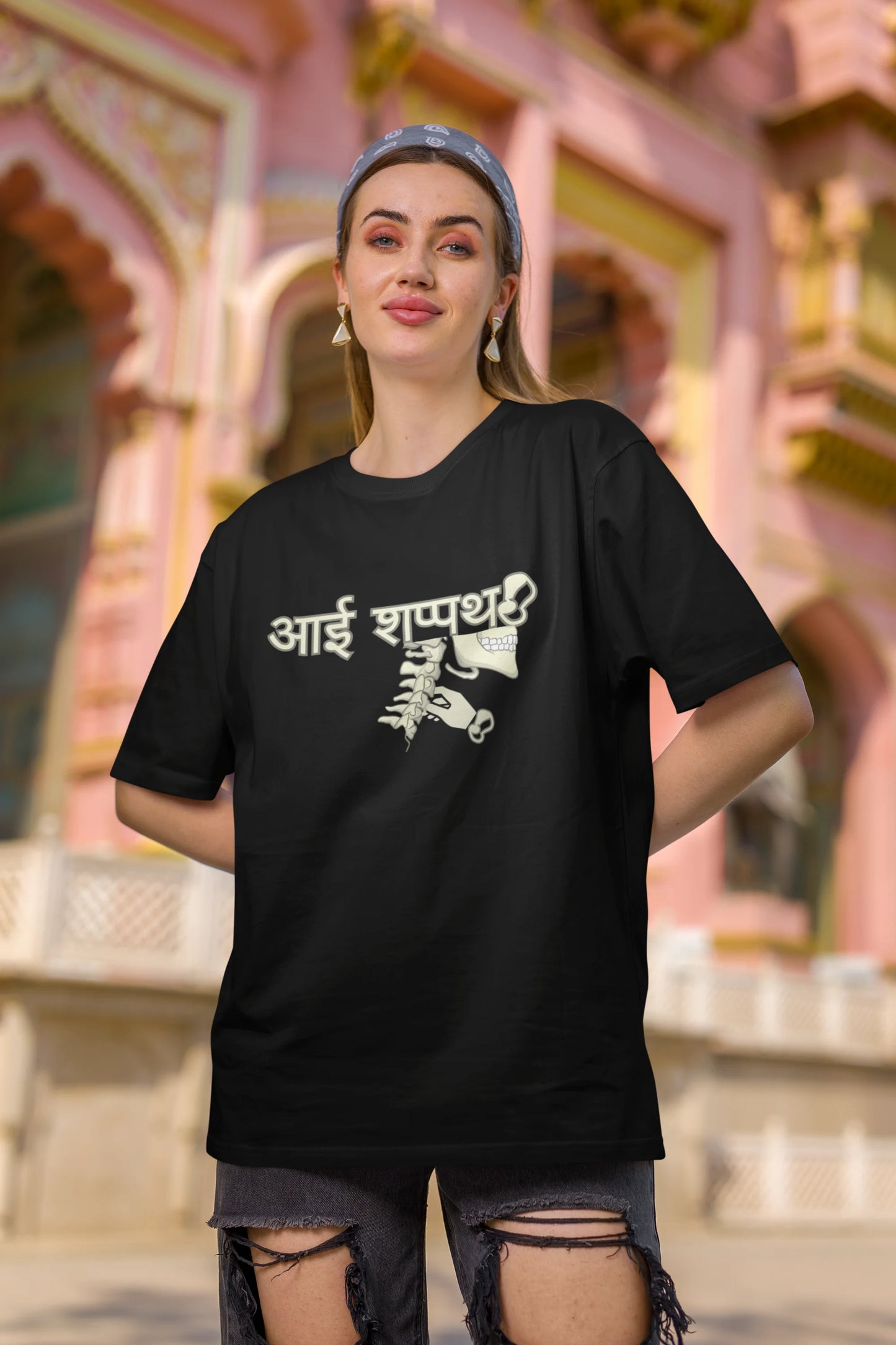 Third front view of female model wearing a black oversized t-shirt featuring a design inspired by the Marathi saying "Aai Sapath." Perfect for fans of Marathi culture and anyone who wants to celebrate their heritage.