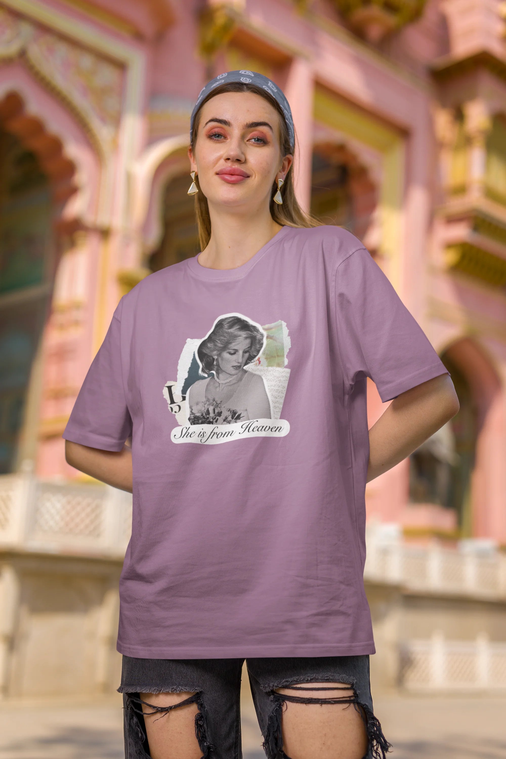 Third front view of female model wearing a dirty purple oversized t-shirt featuring a black and white photo of Princess Diana with the text "She is from Heaven." Ideal for fans of Princess Diana and those who want to celebrate a royal icon.