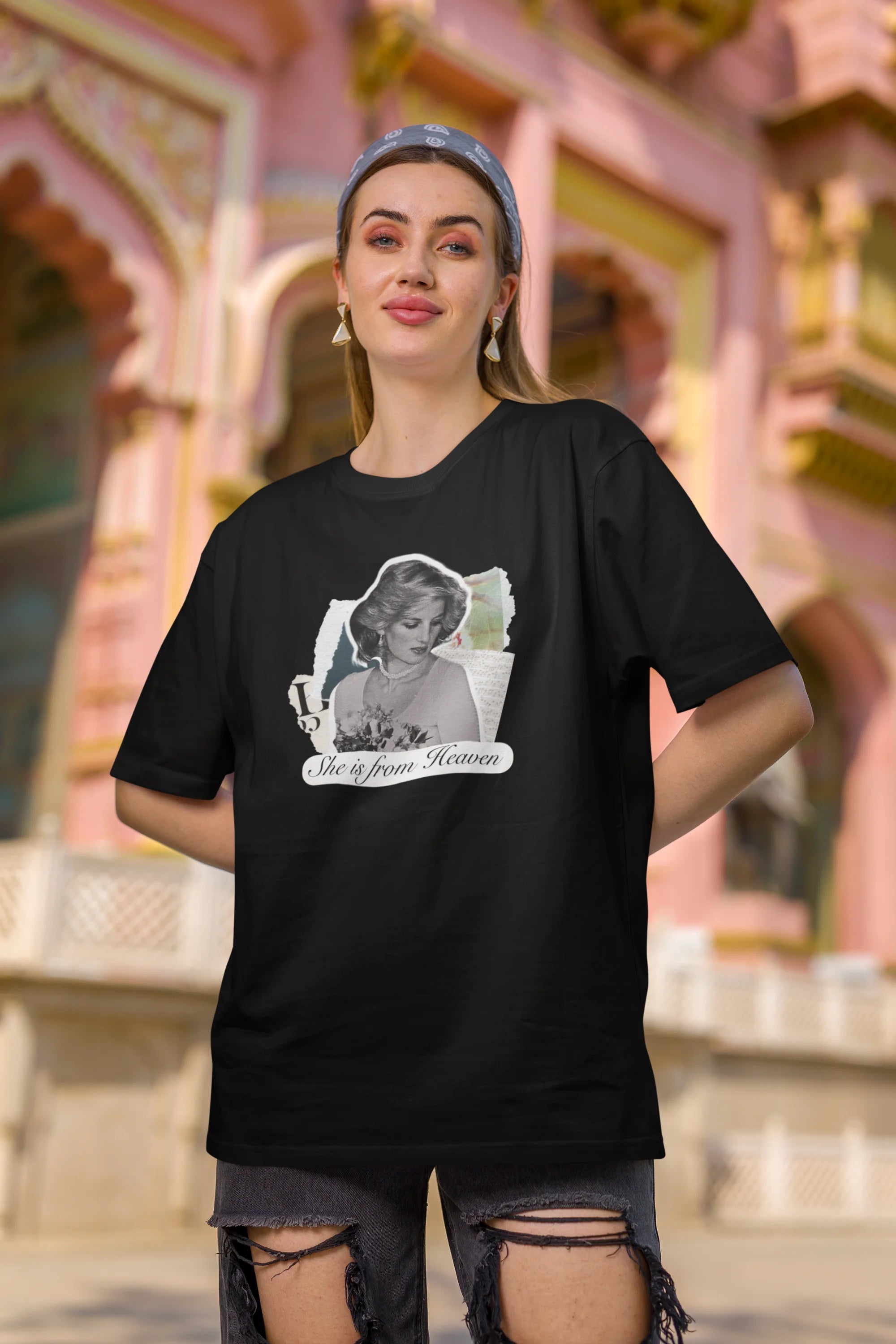 Second front view of female model wearing a black oversized t-shirt featuring a black and white photo of Princess Diana with the text "She is from Heaven." Ideal for fans of Princess Diana and those who want to celebrate a royal icon.