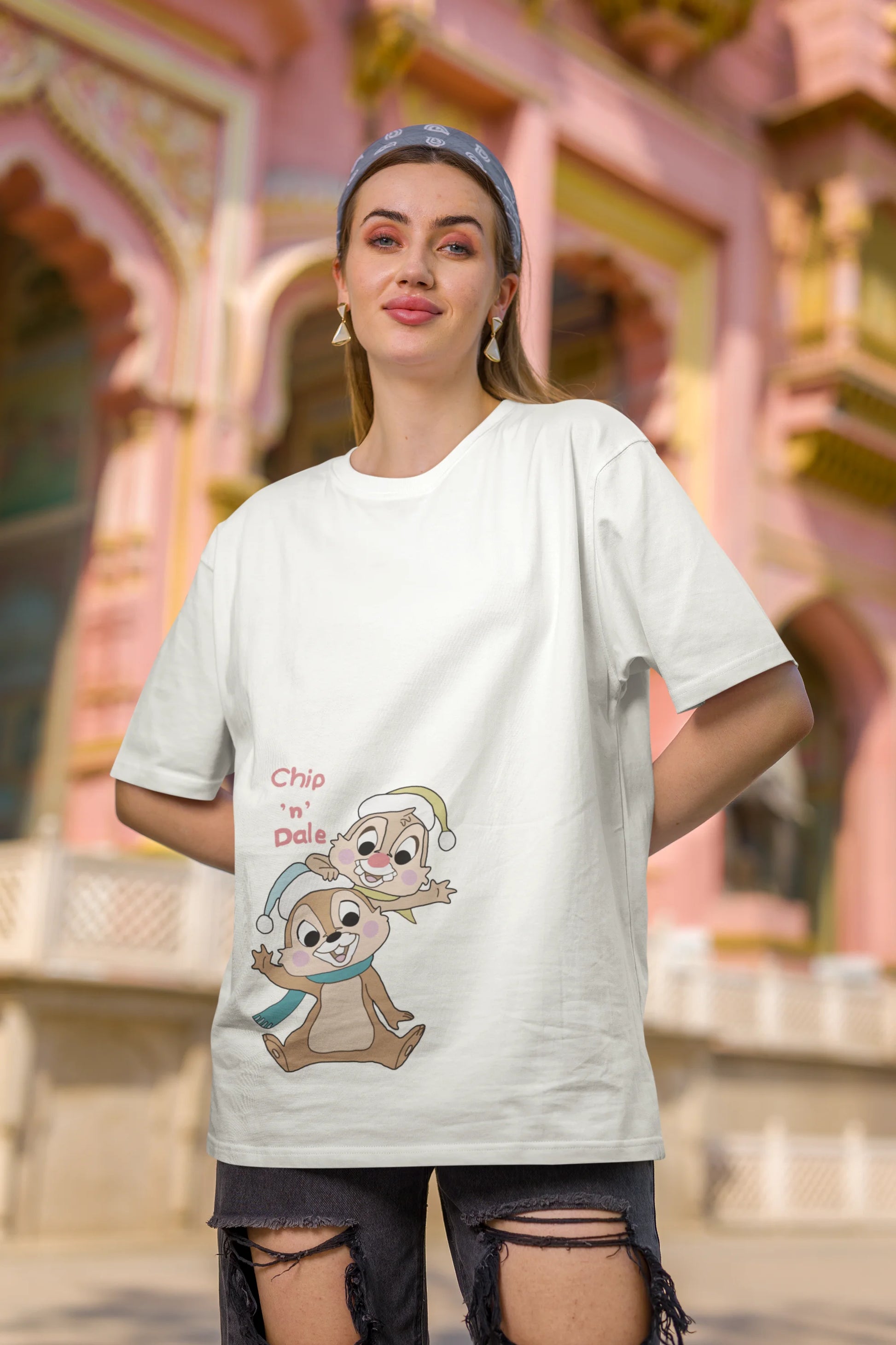 Third image of female model wearing off-white oversized tee with a Disney's Chip and Dale design, featuring the adorable duo in a playful scene.