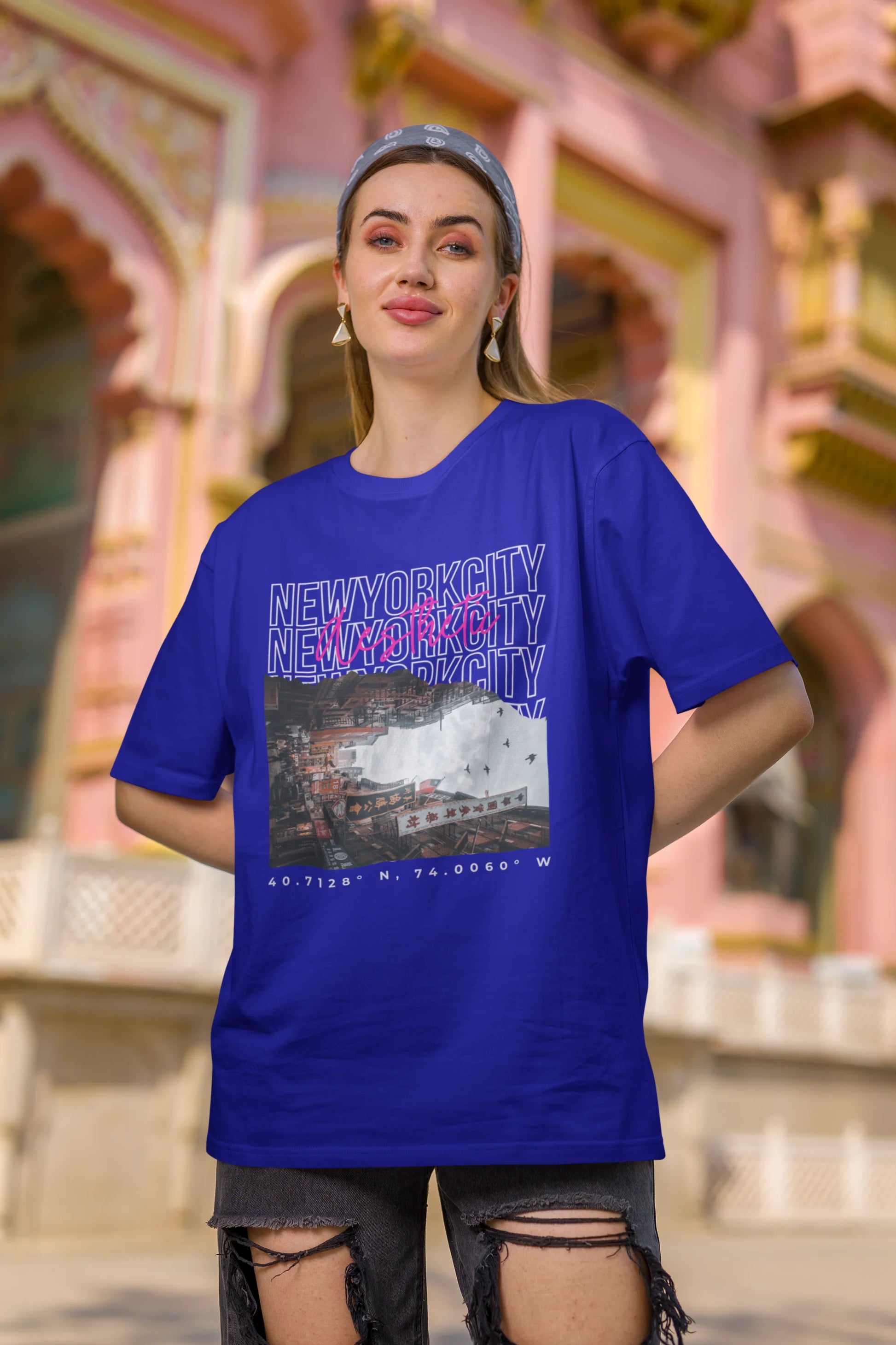 Second front view of a female model wearing a royal blue oversized t-shirt with a New York City skyline design, offering a relaxed urban aesthetic.