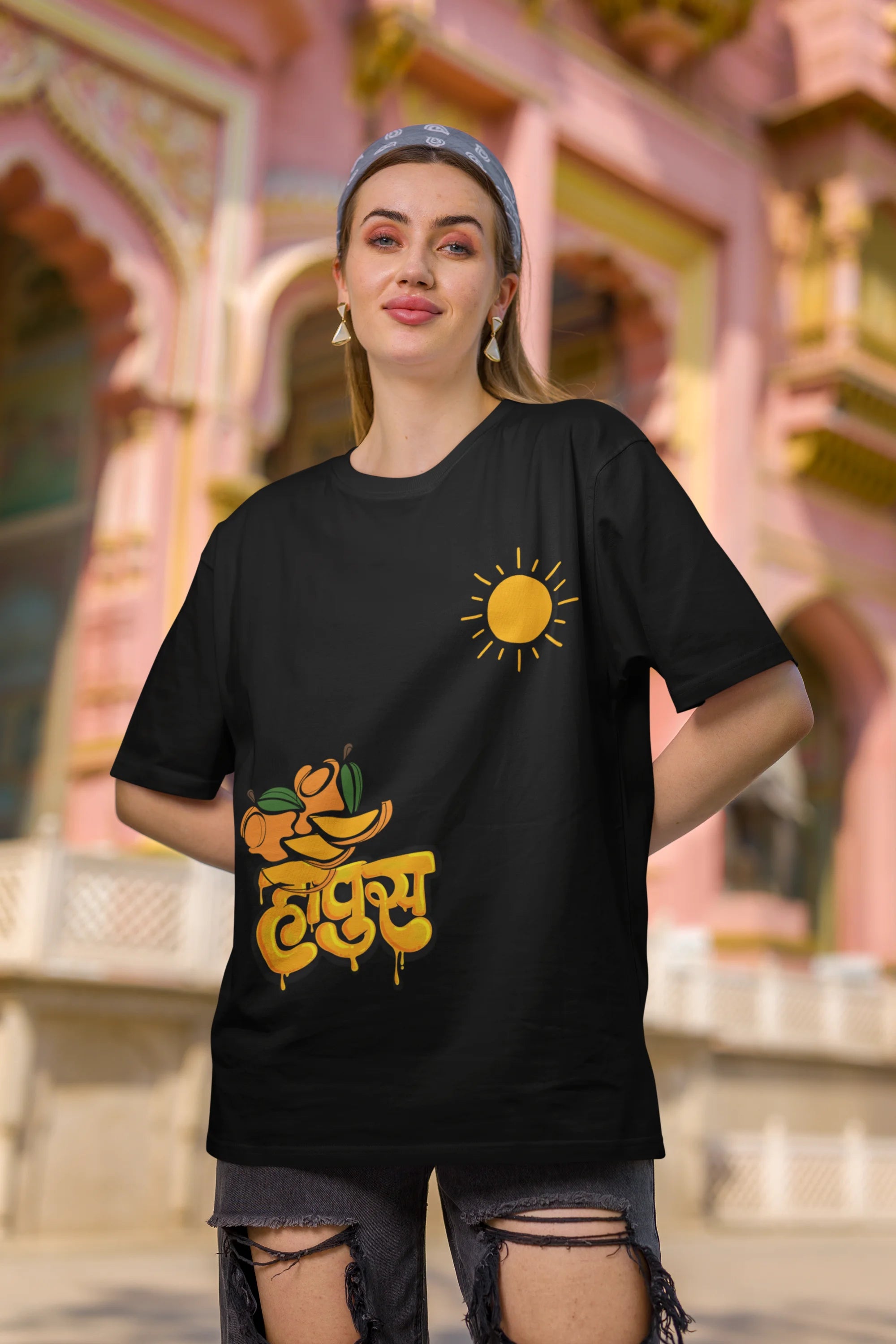 Second front view of female model wearing an black oversized t-shirt featuring a design inspired by the Marathi word "Hapus," meaning Alphonso mango. Ideal for fans of Marathi culture, foodies, and anyone who loves the king of fruits.