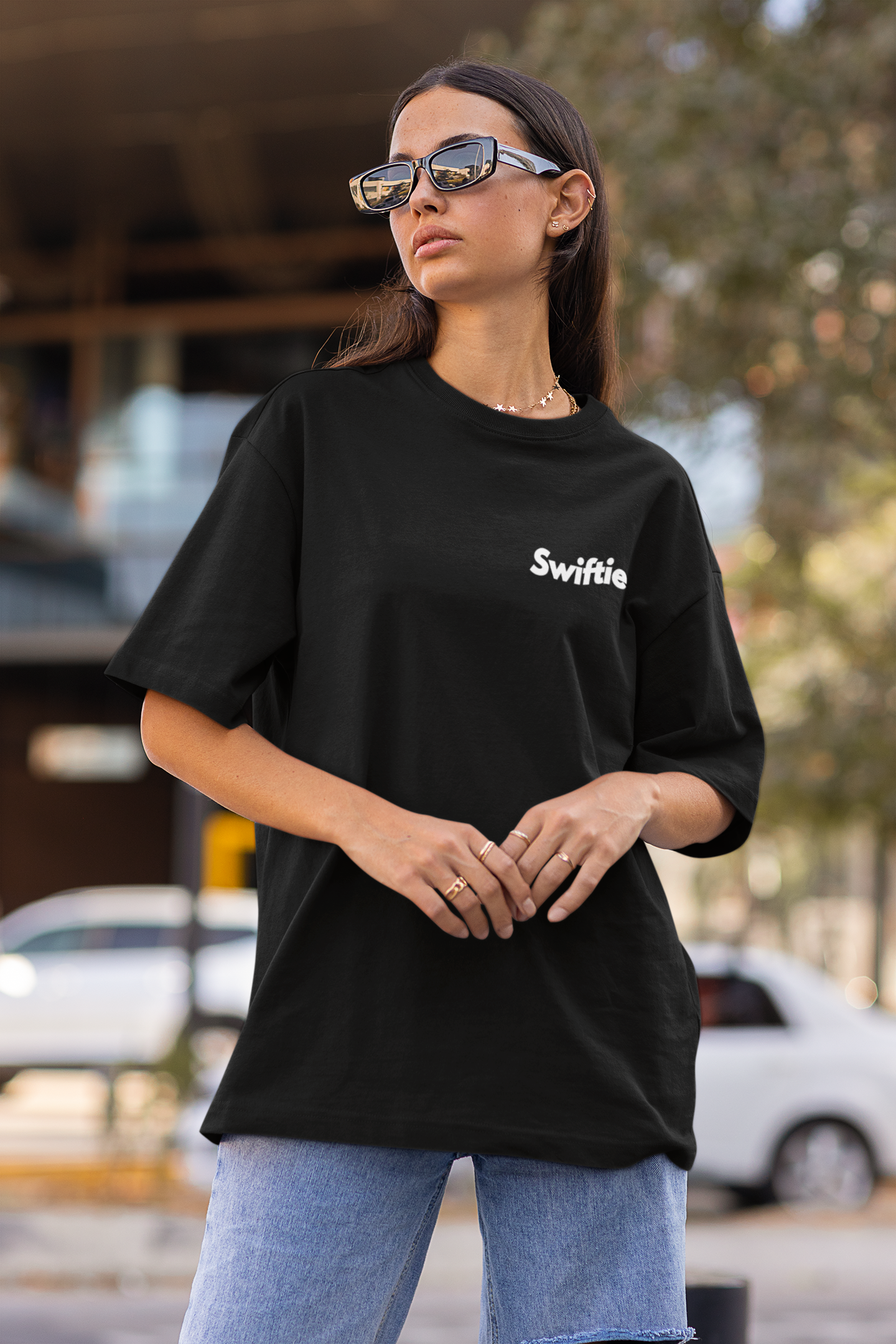 Side view of woman wearing black Oversize T-shirt featuring Swiftie design, taylor's version