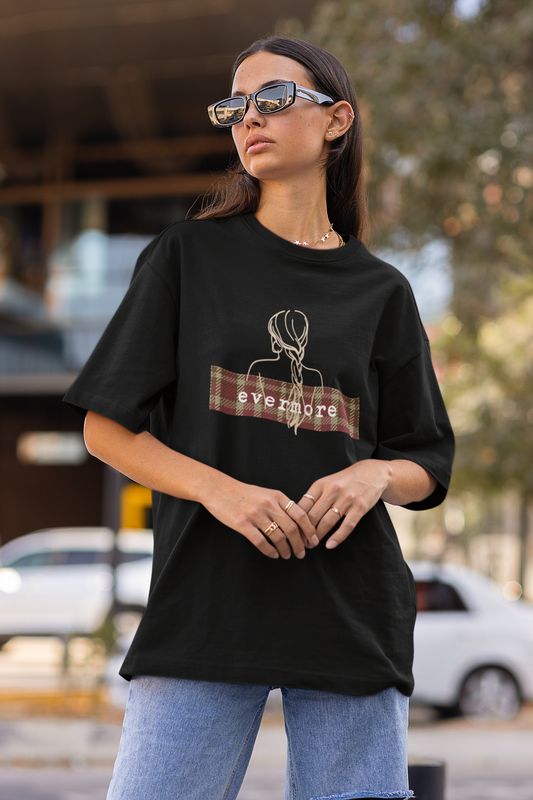 Side view of female model showcasing black oversized Taylor Swift Evermore design T-shirt from the Taylors Version Swiftie merch collection