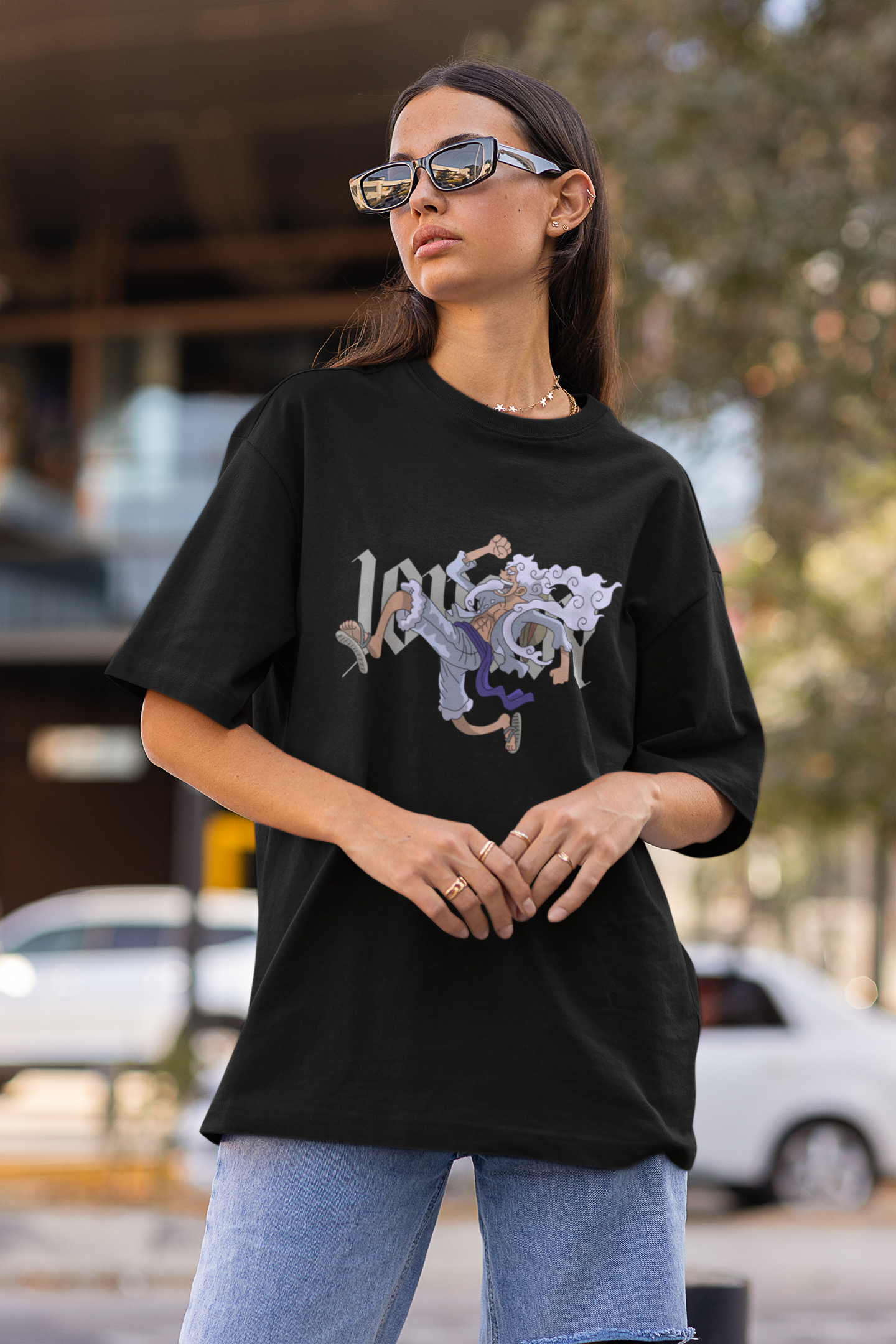 First front view of a female model wearing a black oversized t-shirt featuring Luffy in his Gear 5 form from the One Piece anime.