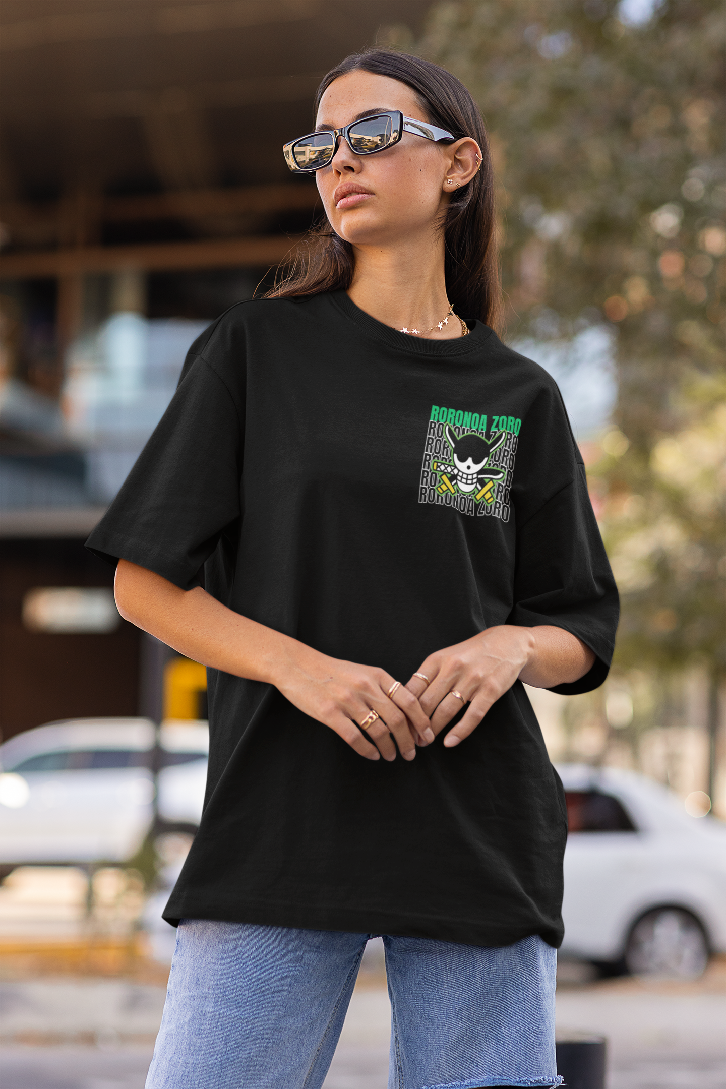 2nd front view of a female model wearing a black oversized t-shirt featuring Roronoa Zoro from the One Piece anime.