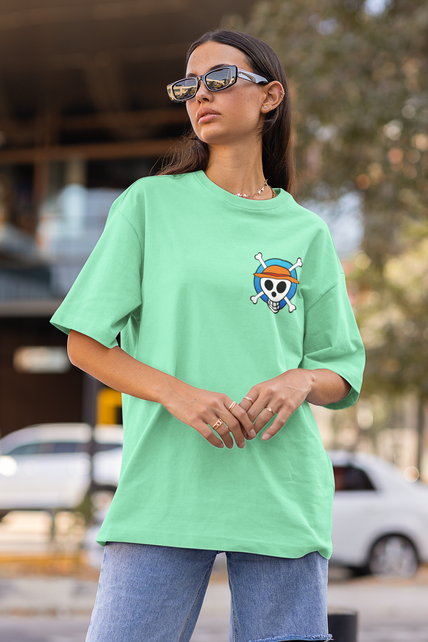 First front view of a female model wearing a mint green oversized t-shirt featuring chibi versions of the main characters from the One Piece anime.