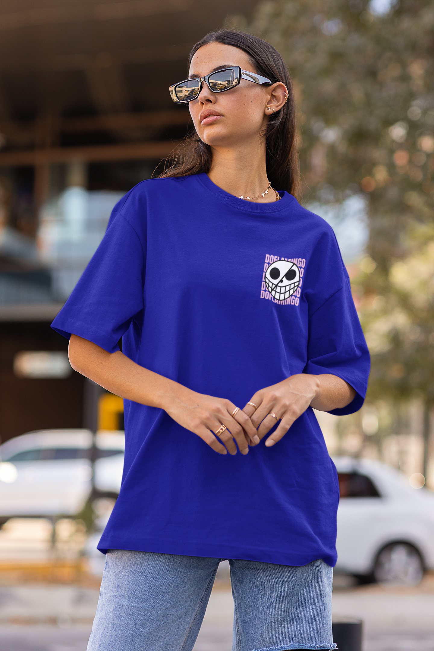 3rd front view of a female model wearing a royal blue oversized t-shirt featuring Donquixote Doflamingo from the One Piece anime.
