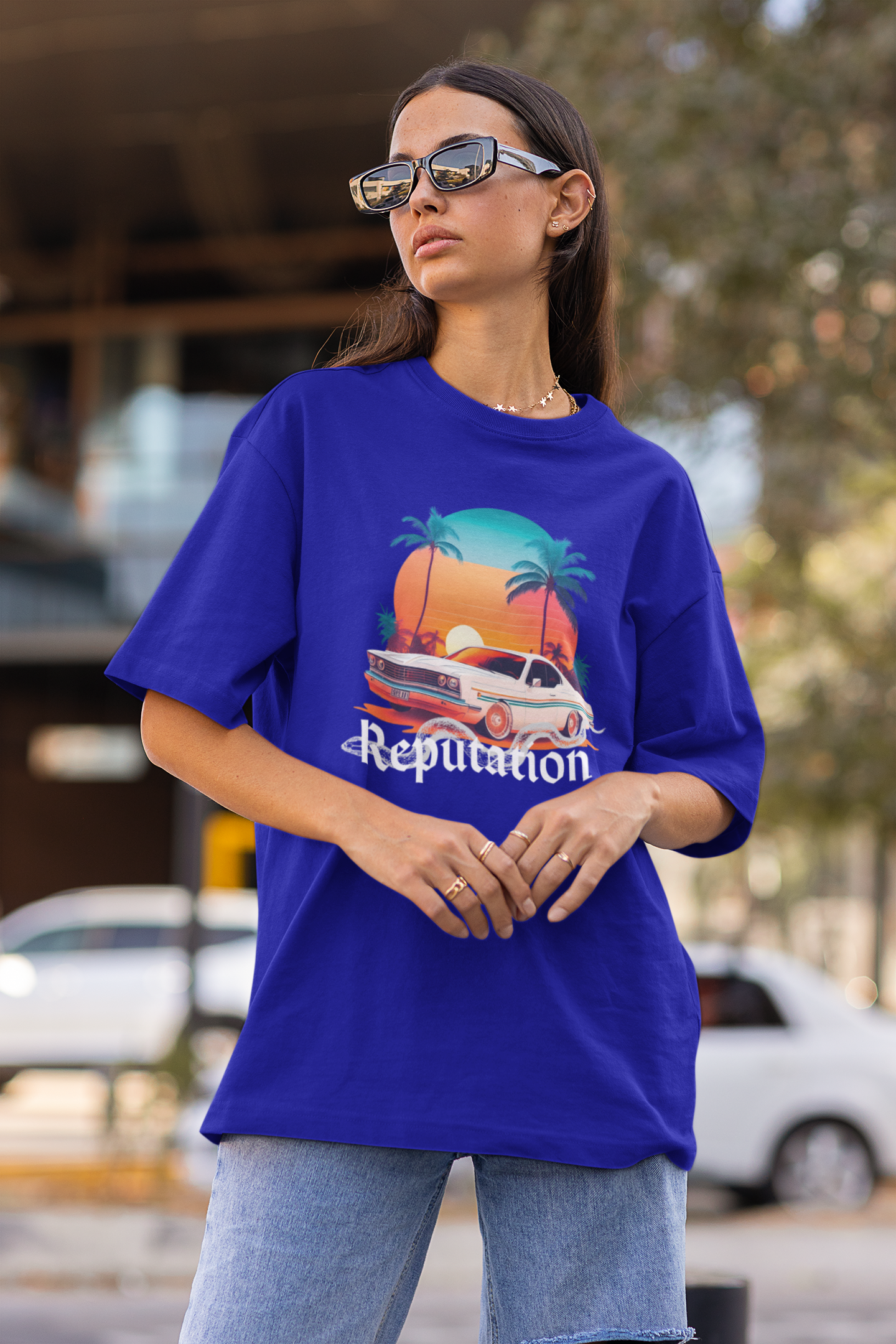 Side view of woman wearing blue Oversize t-shirt featuring Reputation Taylor's Version design inspired by Taylor Swift's Reputation era