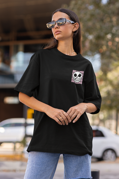 3rd front view of a female model wearing a black oversized t-shirt featuring Donquixote Doflamingo from the One Piece anime.