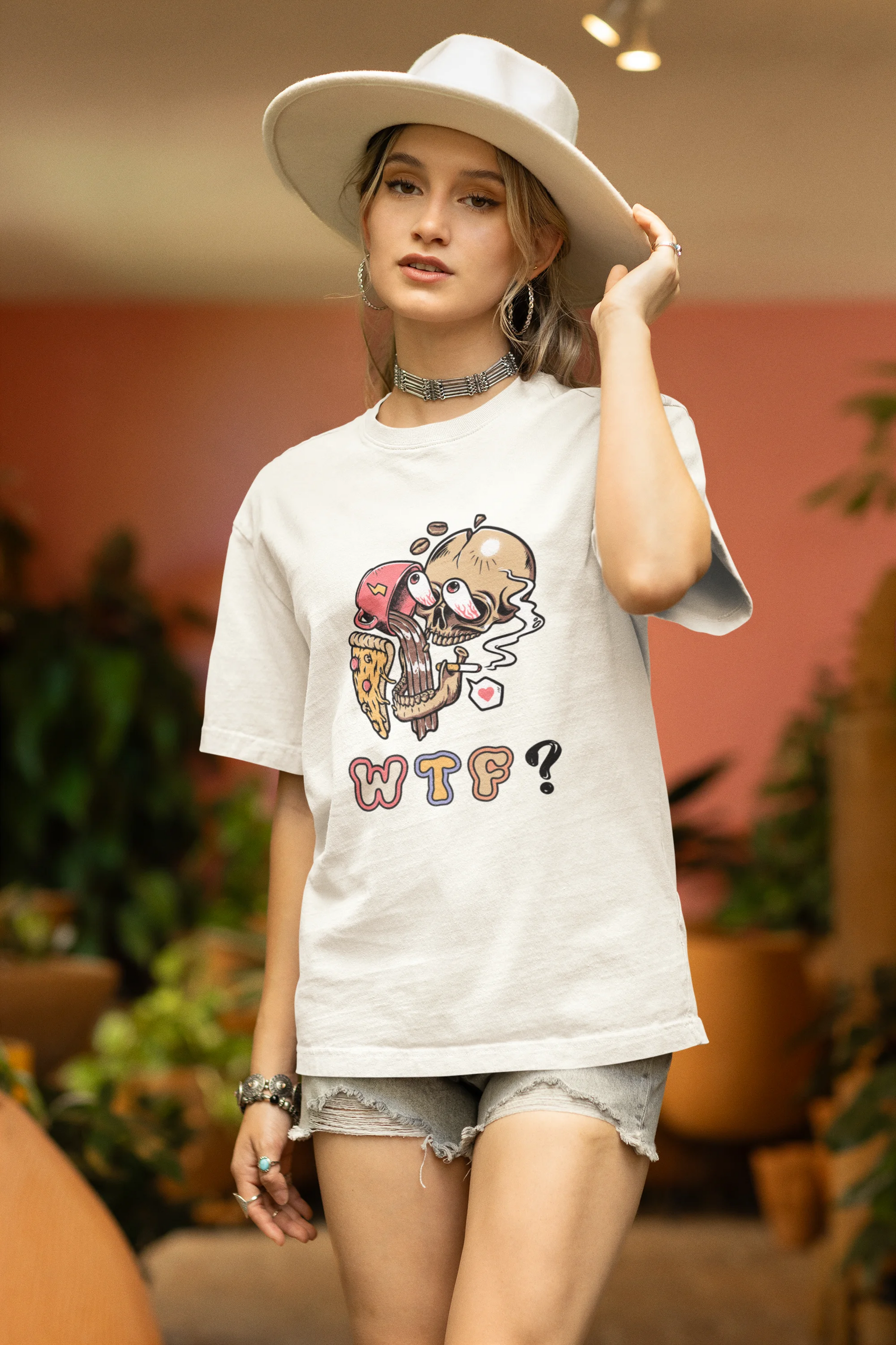 Side view of a female model wearing an off white oversized t-shirt featuring a skull enjoying coffee, pizza, and smoking, offering a unique and edgy aesthetic.