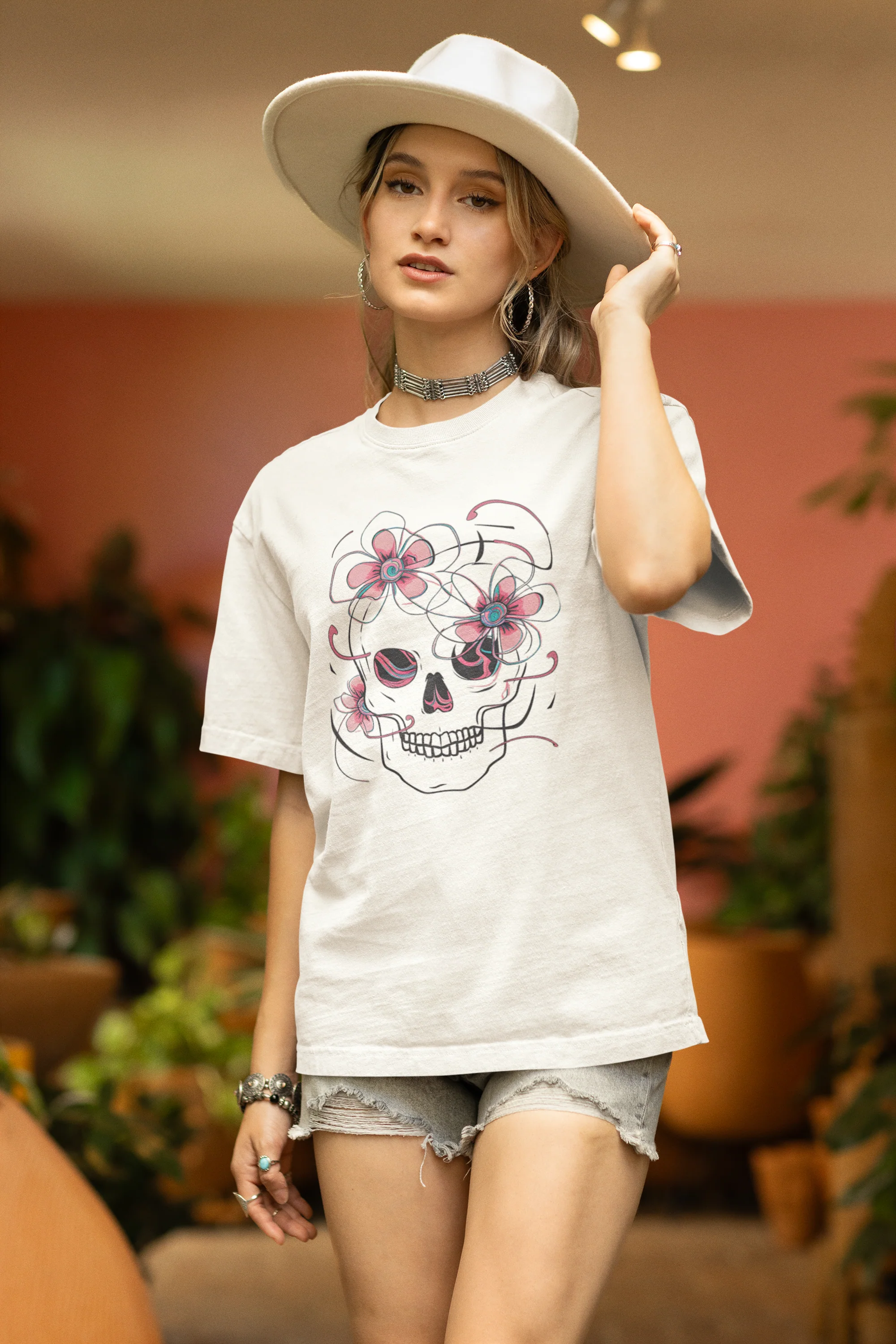 Side view of female model wearing an off-white oversized t-shirt with a psychedelic skull flower design, perfect for a hippie, trance, or groovy style.