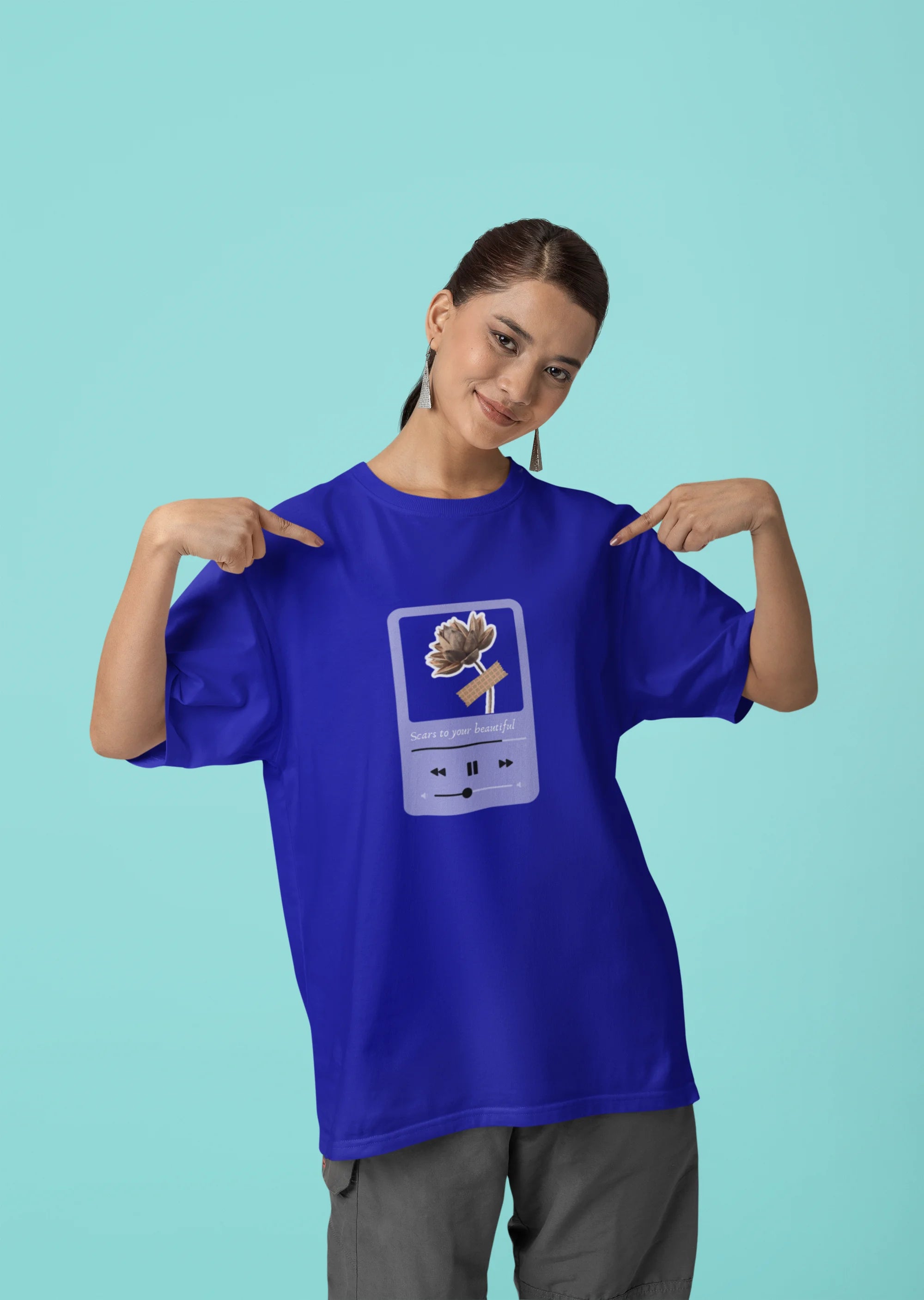 First front view of a female model wearing a royal blue oversized t-shirt featuring a design inspired by Alessia Cara's song "Scars to Your Beautiful." The design includes flowers and a message of self-love. Ideal for fans of Alessia Cara and those who appreciate messages of empowerment.