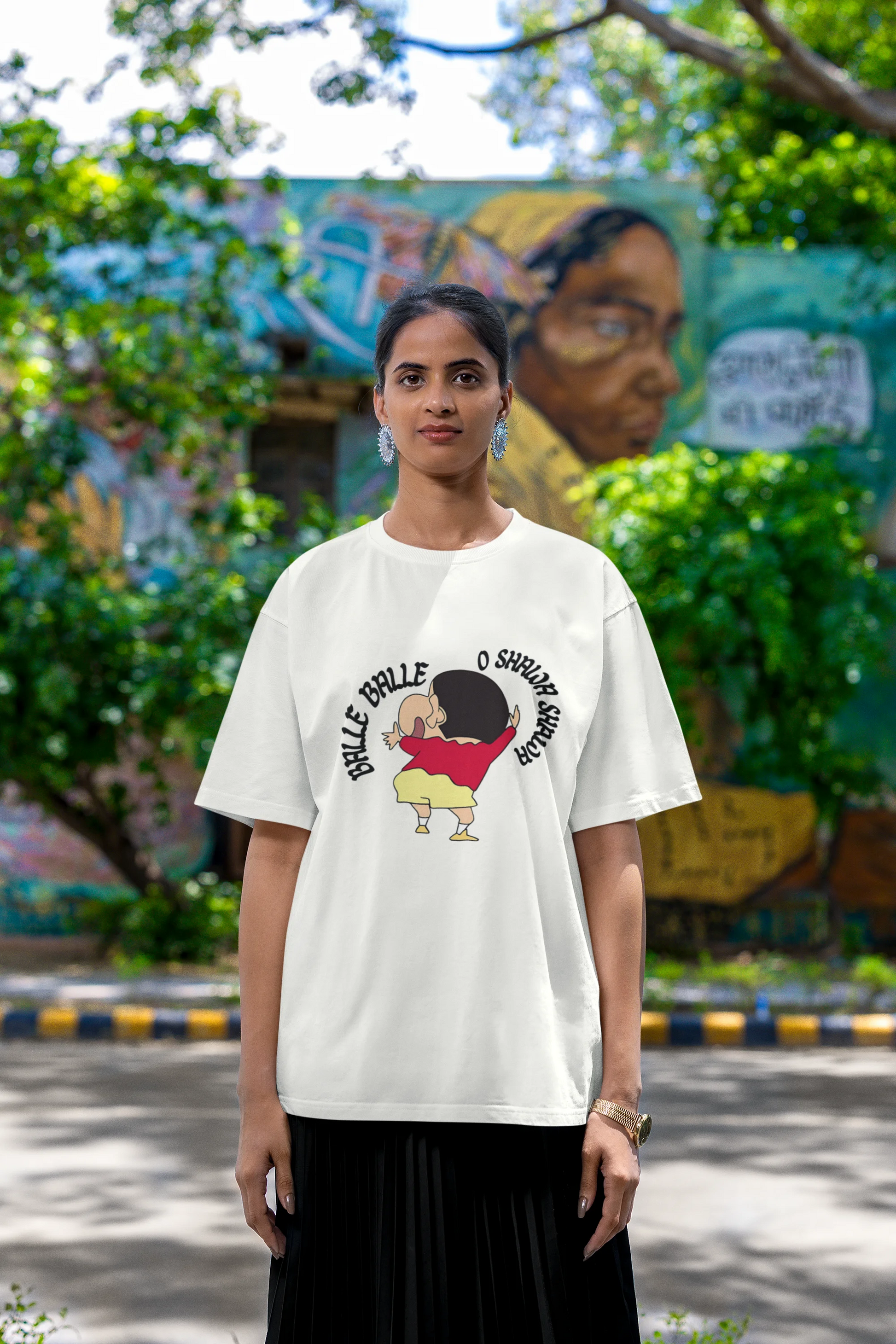 Fourth front view of female model wearing an oversized off-white tee with Shinchan dancing and the text "Balle Balle". A perfect blend of anime and Bollywood for Shinchan fans.