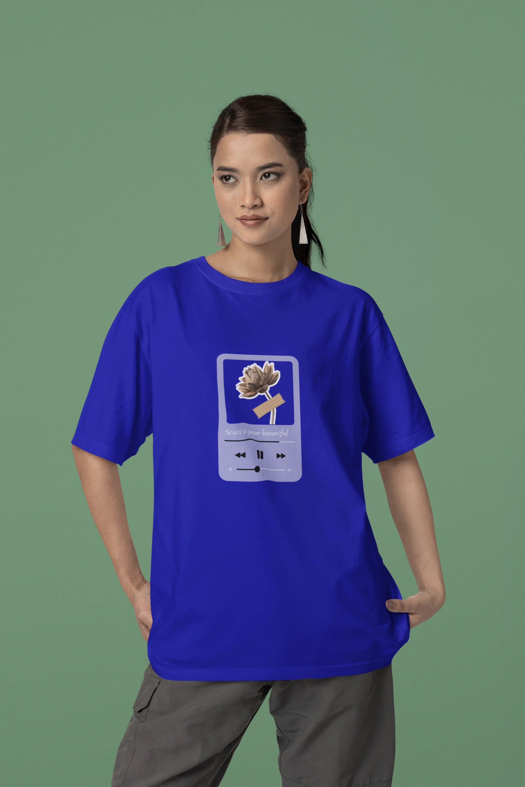 Second front view of a female model wearing a royal blue oversized t-shirt featuring a design inspired by Alessia Cara's song "Scars to Your Beautiful." The design includes flowers and a message of self-love. Ideal for fans of Alessia Cara and those who appreciate messages of empowerment.