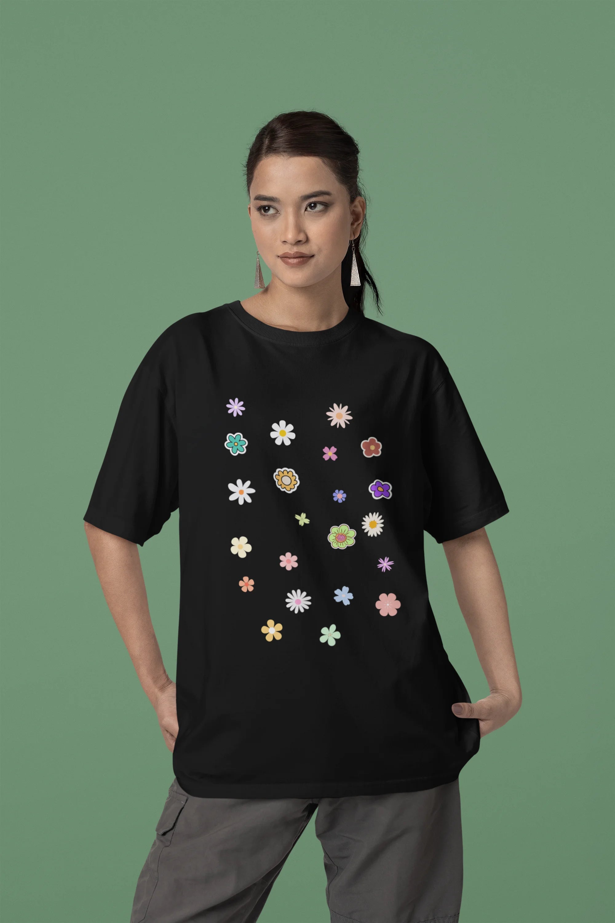 Side view of female model wearing a black oversized t-shirt featuring a vibrant floral design with roses, tulips, sunflowers, and orchids. Ideal for those who love floral patterns and spring fashion. 