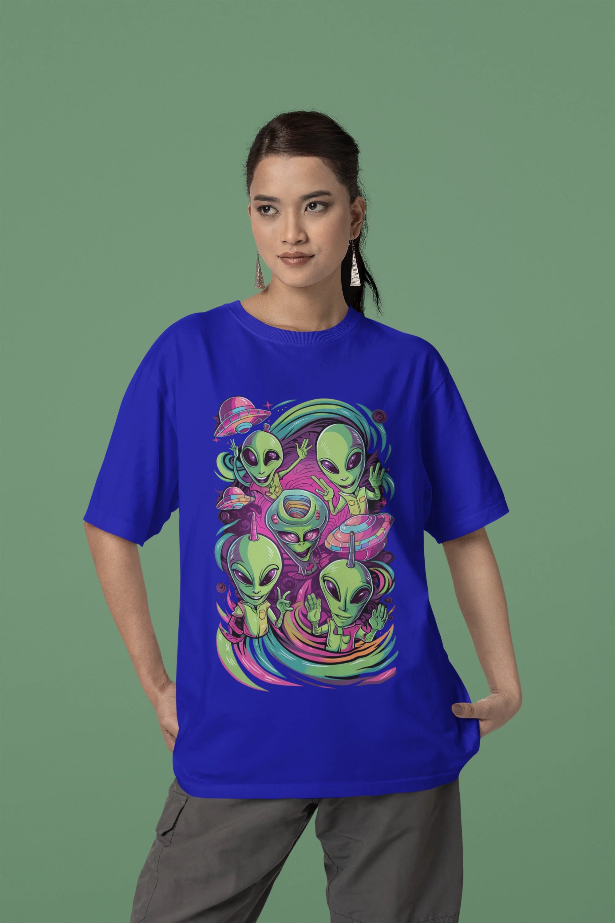 First front view of a female model wearing a royal blue oversized t-shirt with a psychedelic design featuring green aliens and spaceships, perfect for a hippie, trance, or groovy style.