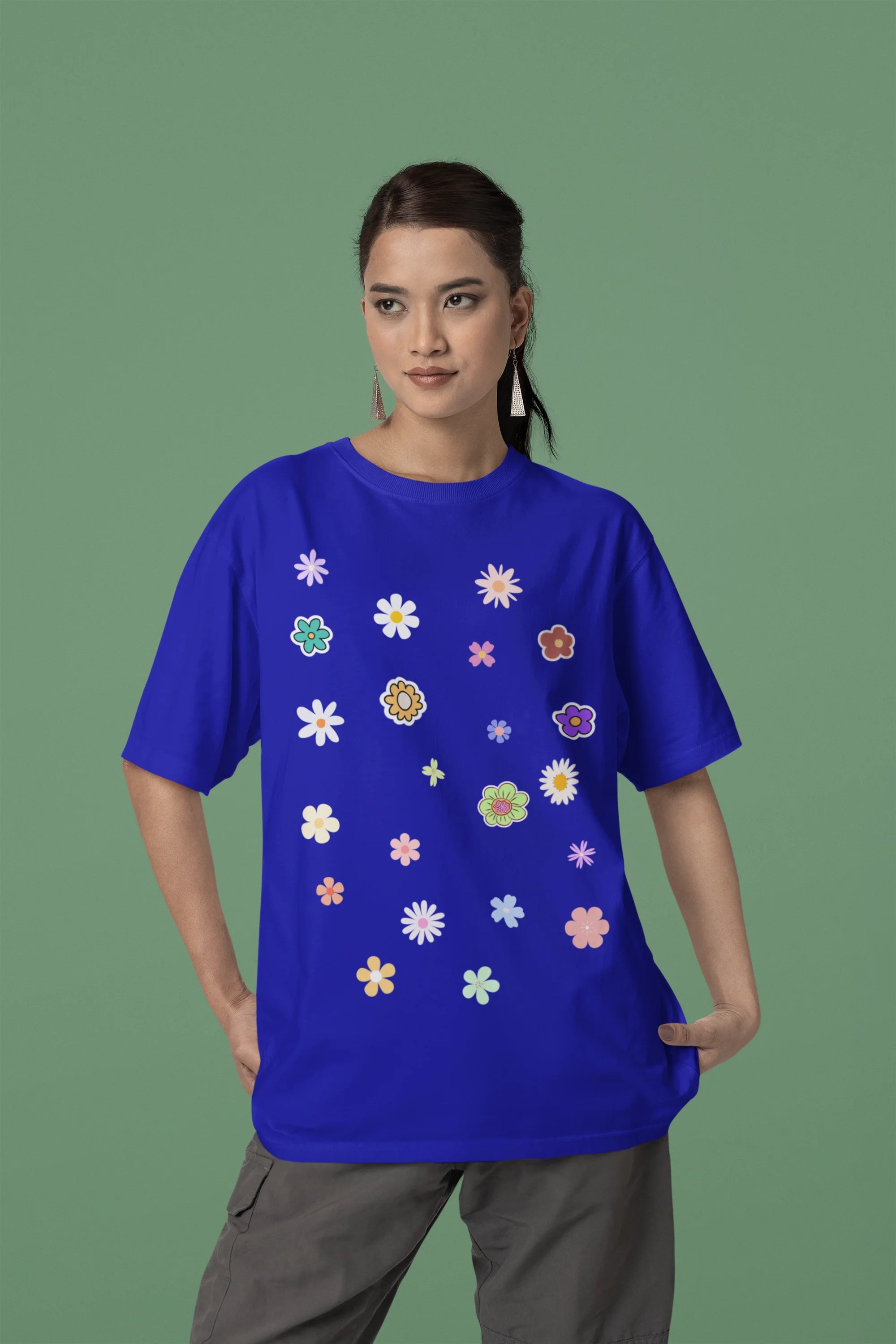 Side view of female model wearing a royal blue oversized t-shirt featuring a vibrant floral design with roses, tulips, sunflowers, and orchids. Ideal for those who love floral patterns and spring fashion. 