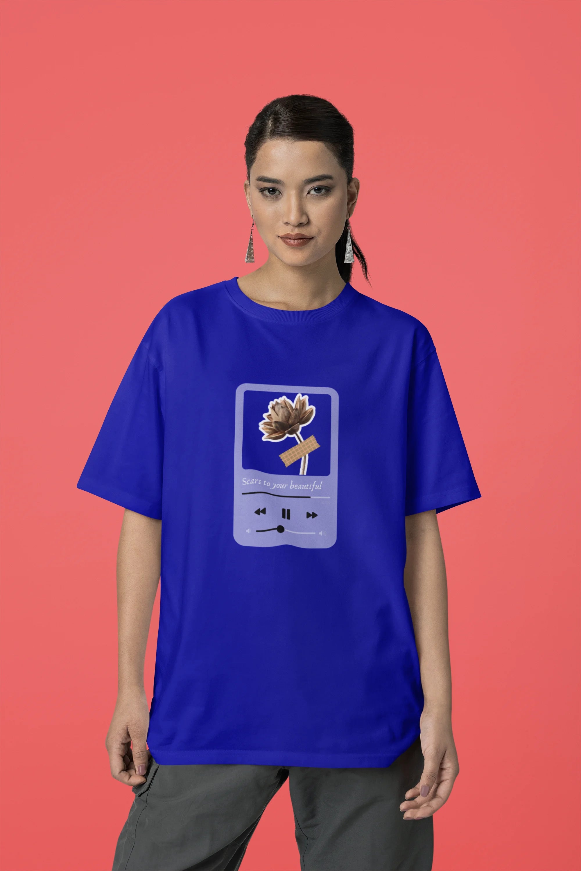 Third front view of a female model wearing a royal blue oversized t-shirt featuring a design inspired by Alessia Cara's song "Scars to Your Beautiful." The design includes flowers and a message of self-love. Ideal for fans of Alessia Cara and those who appreciate messages of empowerment.