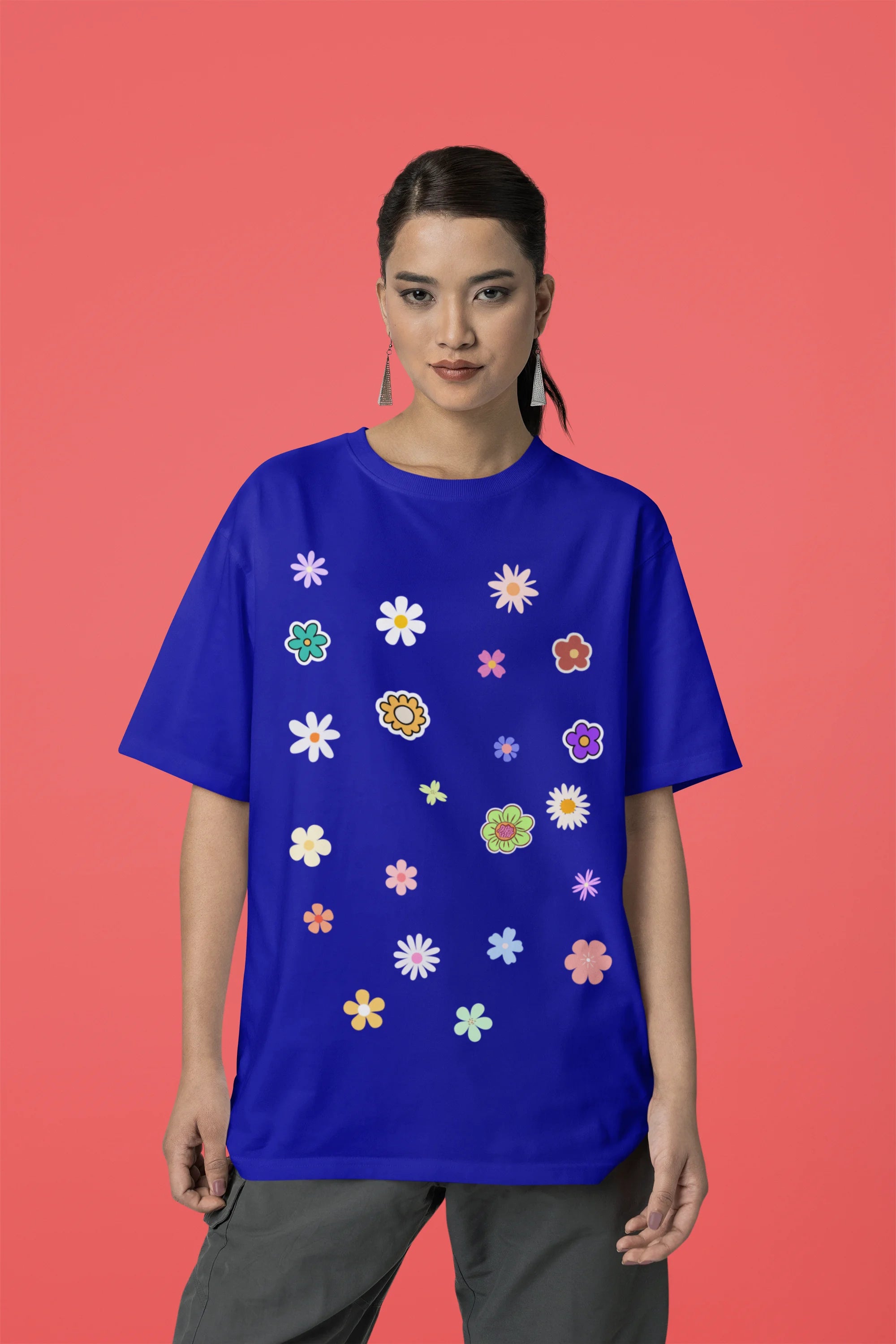 Front view of female model wearing a royal blue oversized t-shirt featuring a vibrant floral design with roses, tulips, sunflowers, and orchids. Ideal for those who love floral patterns and spring fashion. 