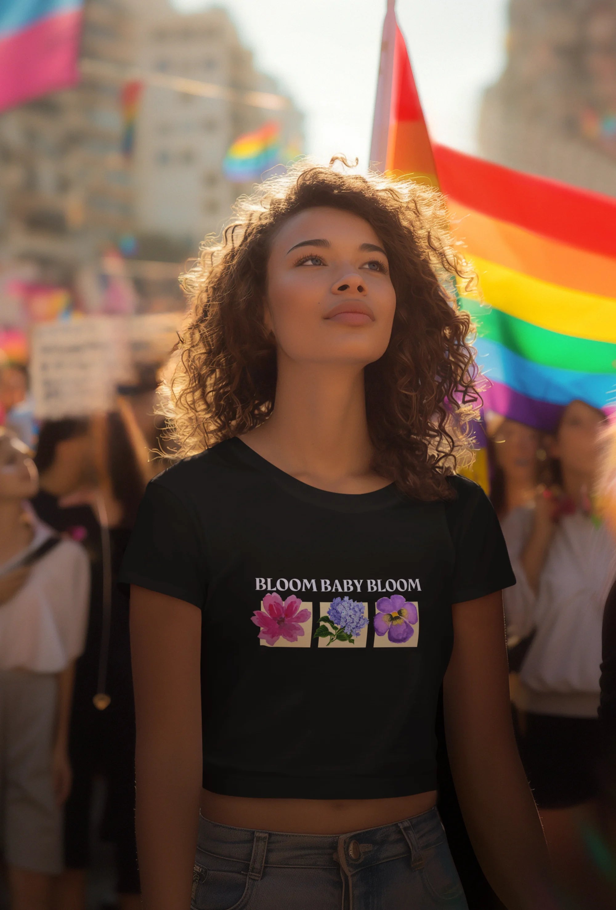 Third front view of a female model wearing a black crop top with a floral "bloom baby bloom" design, exuding a cool and confident vibe.