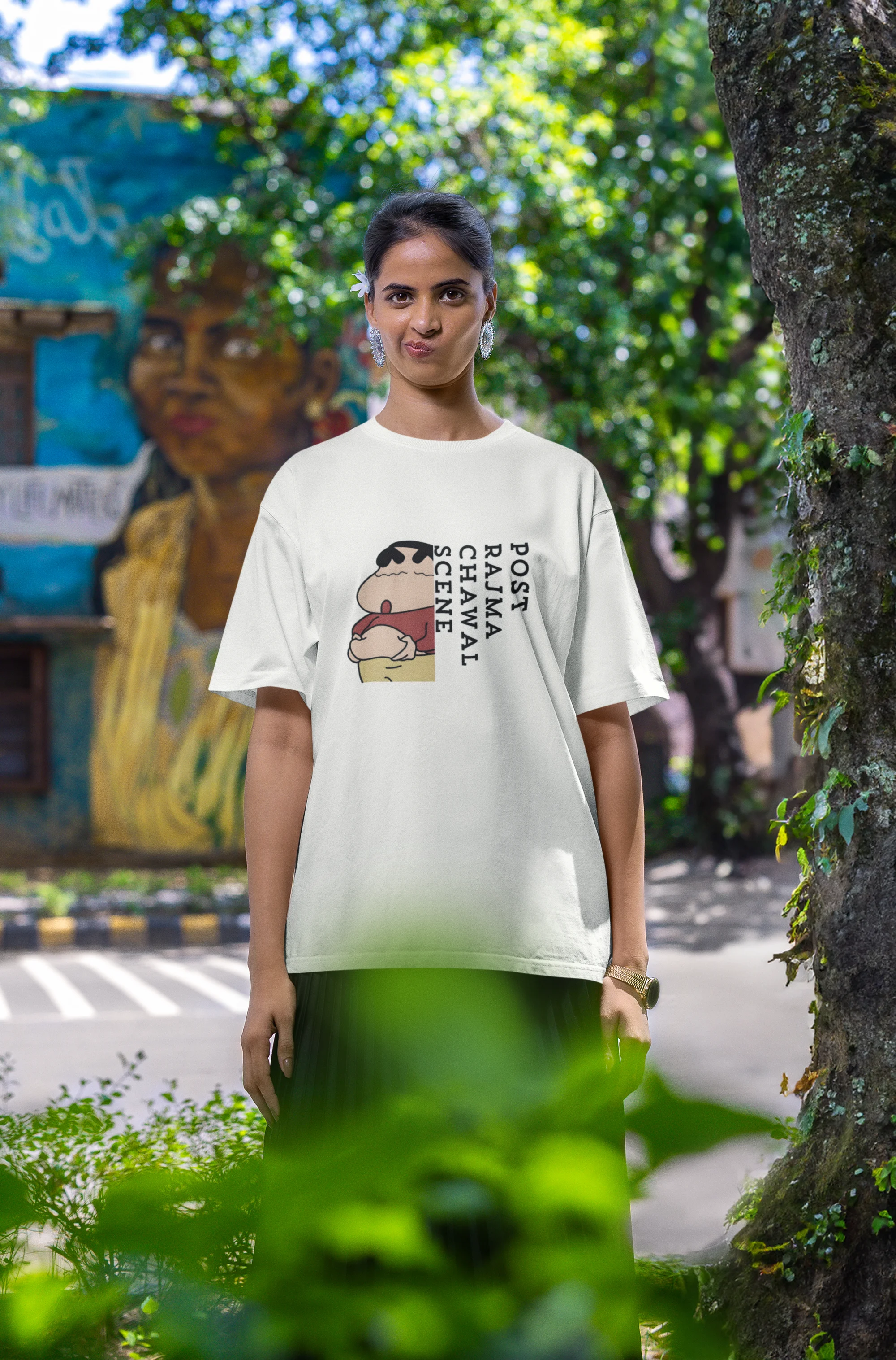 Third front image of female model wearing an oversized off-white tee with a humorous design of Shinchan enjoying a food coma. A must-have for Shinchan fans and food lovers.