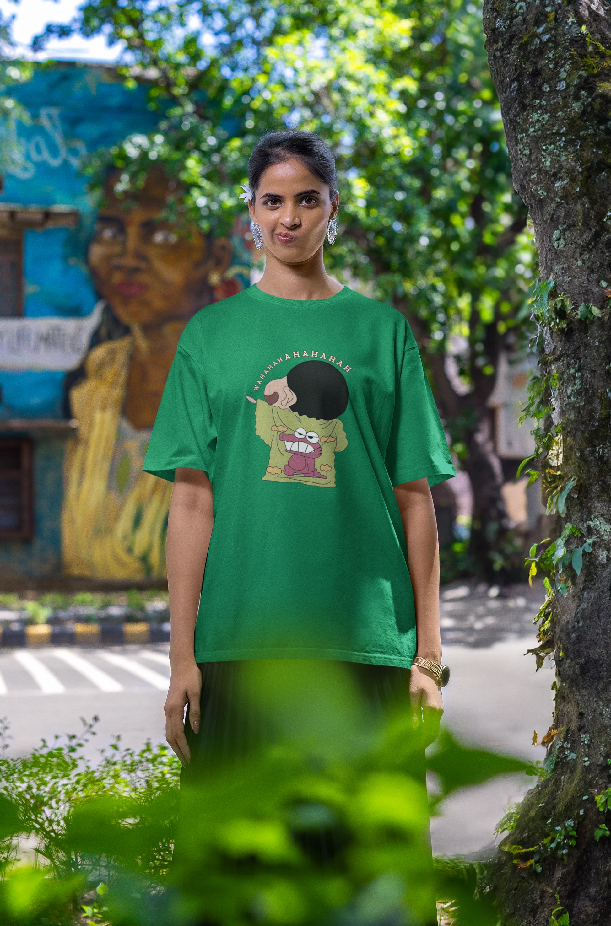 Third front view of female model wearing a forest green oversized t-shirt with a design of Shinchan laughing hysterically. Perfect for Shinchan fans who love the character's humor.