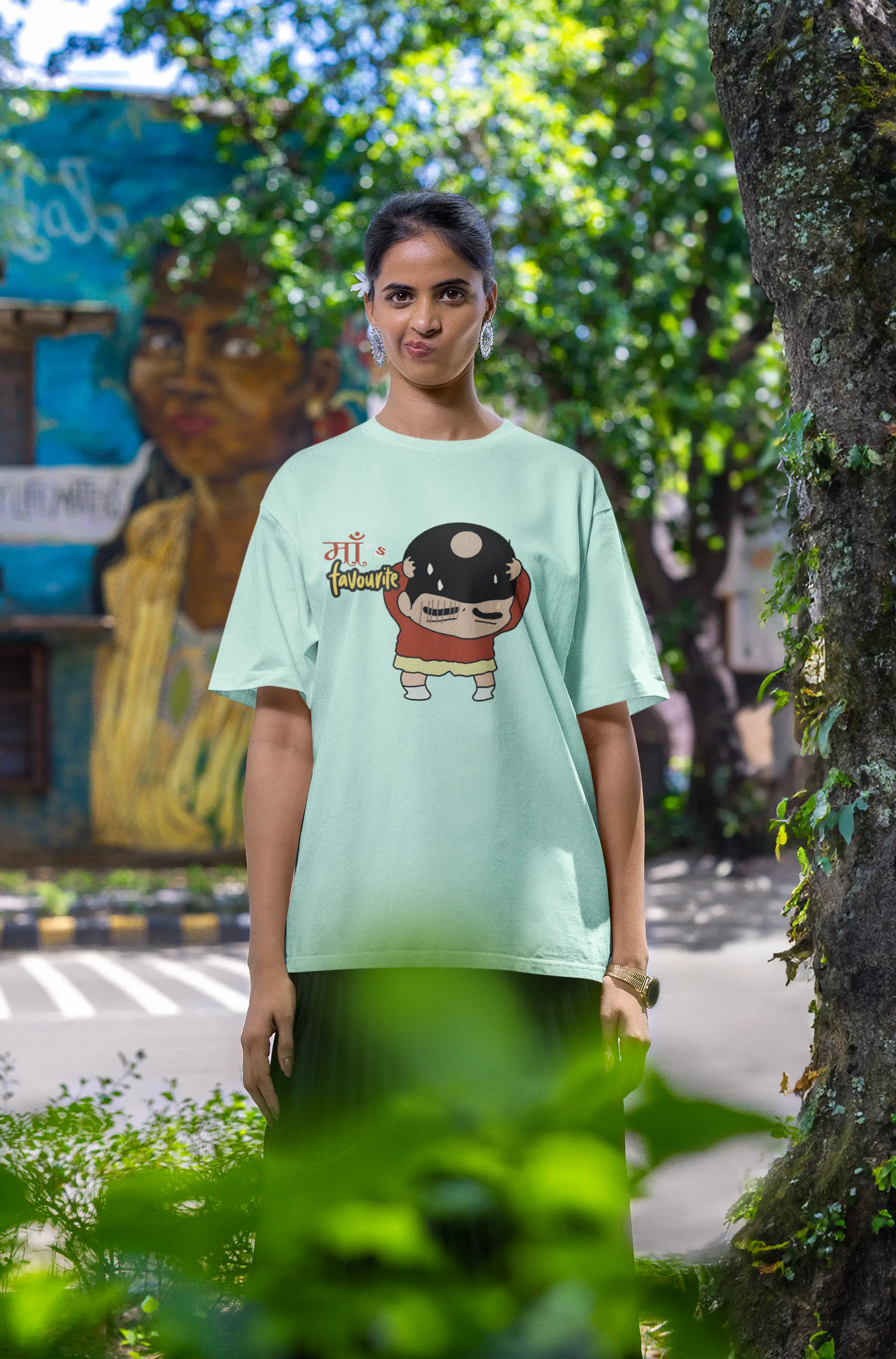 Fourth front view of female model wearing a mint green oversized tee featuring Shinchan with a classic bump on his head. A perfect blend of humor and nostalgia for Shinchan fans.