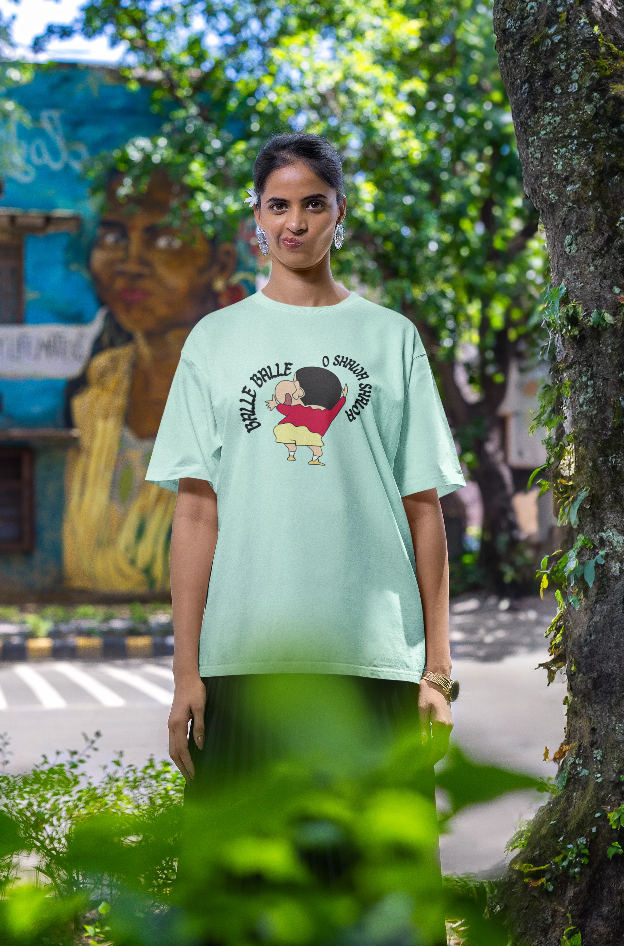 Second front view of female model wearing an oversized mint green tee with Shinchan dancing and the text "Balle Balle". A perfect blend of anime and Bollywood for Shinchan fans.