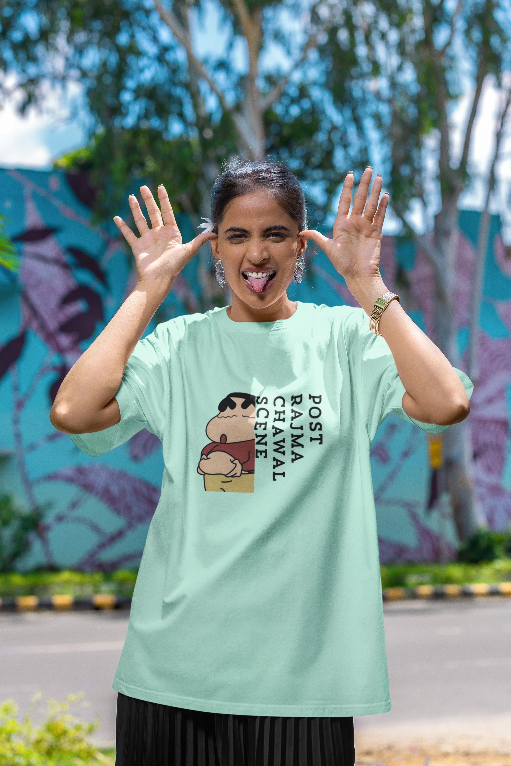 First front image of a female model wearing an oversized mint green tee with a humorous design of Shinchan enjoying a food coma. A must-have for Shinchan fans and food lovers.