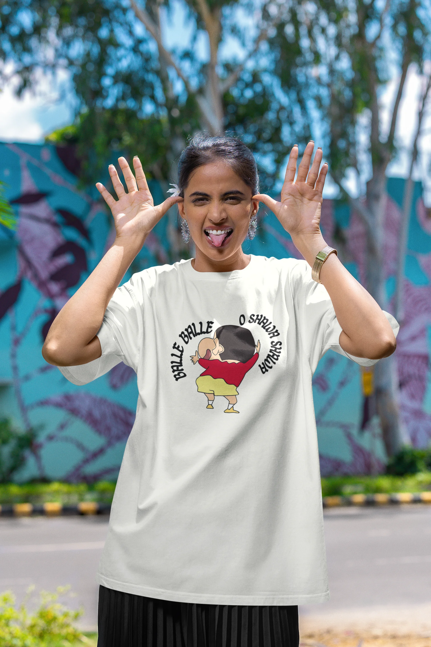 First front view of female model wearing an oversized off-white tee with Shinchan dancing and the text "Balle Balle". A perfect blend of anime and Bollywood for Shinchan fans.
