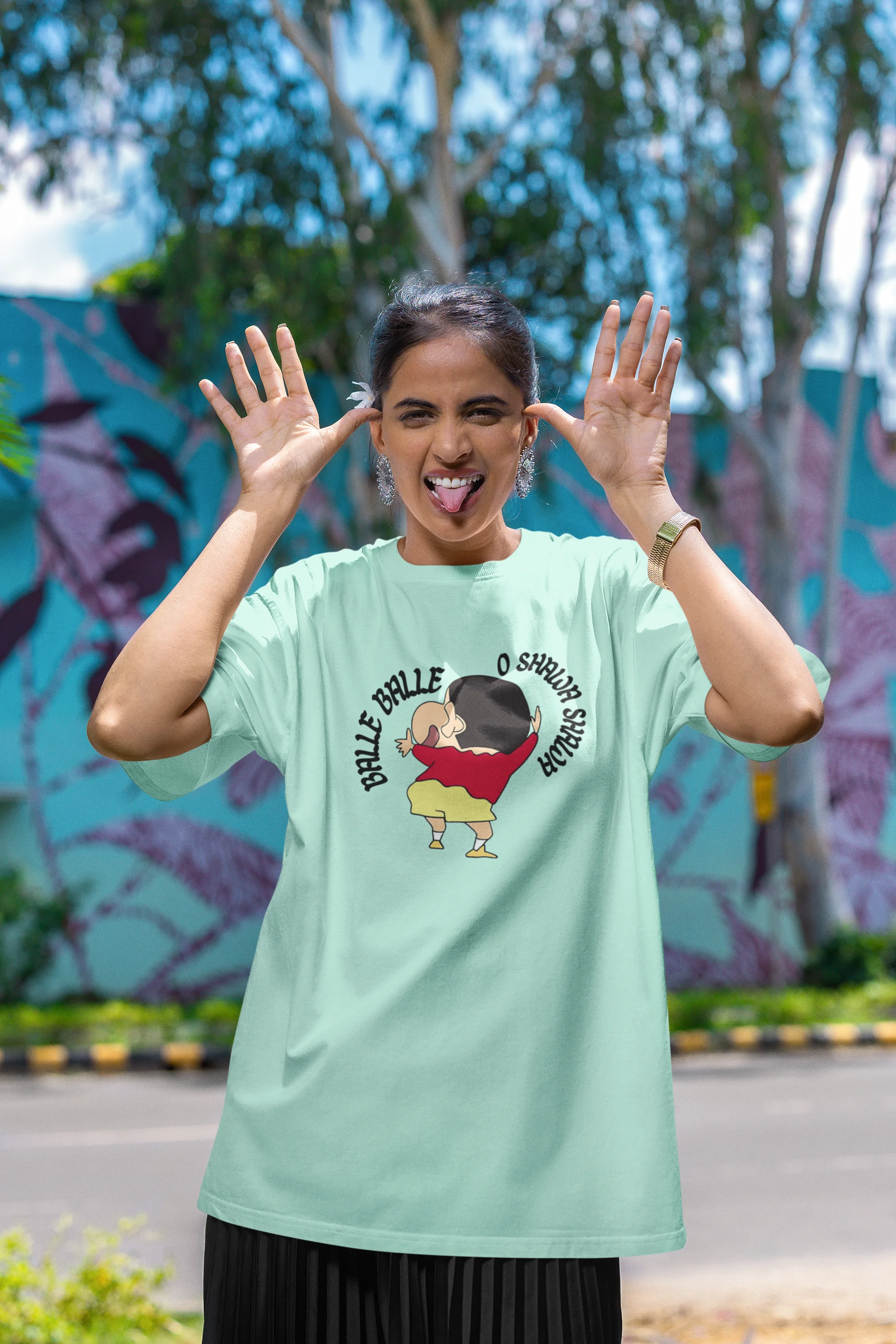 First front view of female model wearing an oversized mint green tee with Shinchan dancing and the text "Balle Balle". A perfect blend of anime and Bollywood for Shinchan fans.