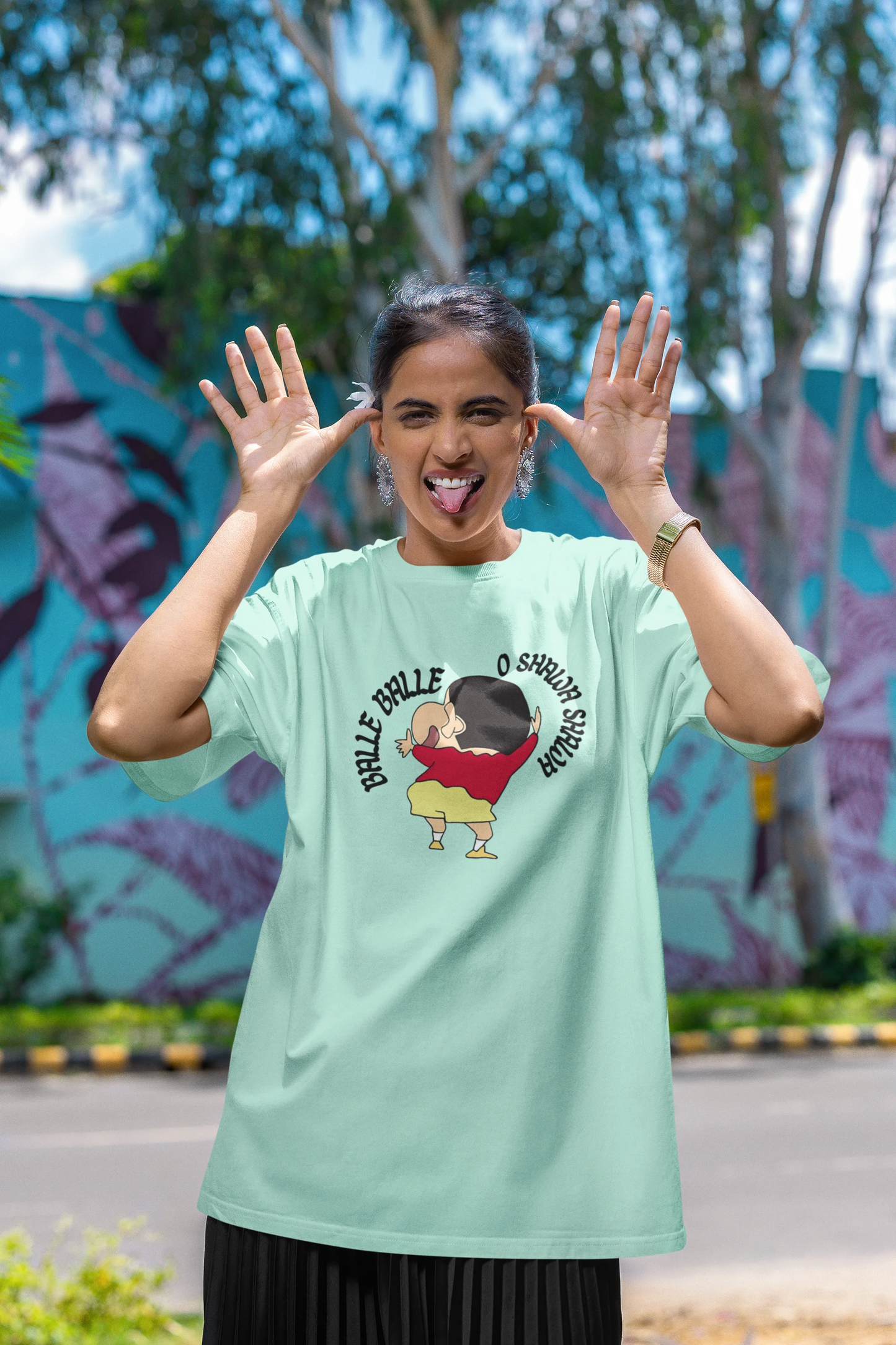 First front view of female model wearing an oversized mint green tee with Shinchan dancing and the text "Balle Balle". A perfect blend of anime and Bollywood for Shinchan fans.